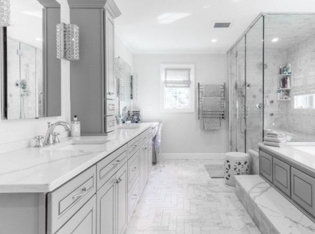 Modern bathroom with marble countertops, a granite floor, and a wood vanity