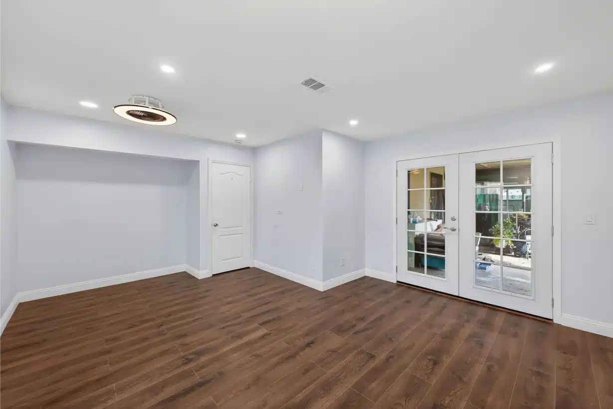 Completed living space in a Santee home remodel with new plank flooring and French doors