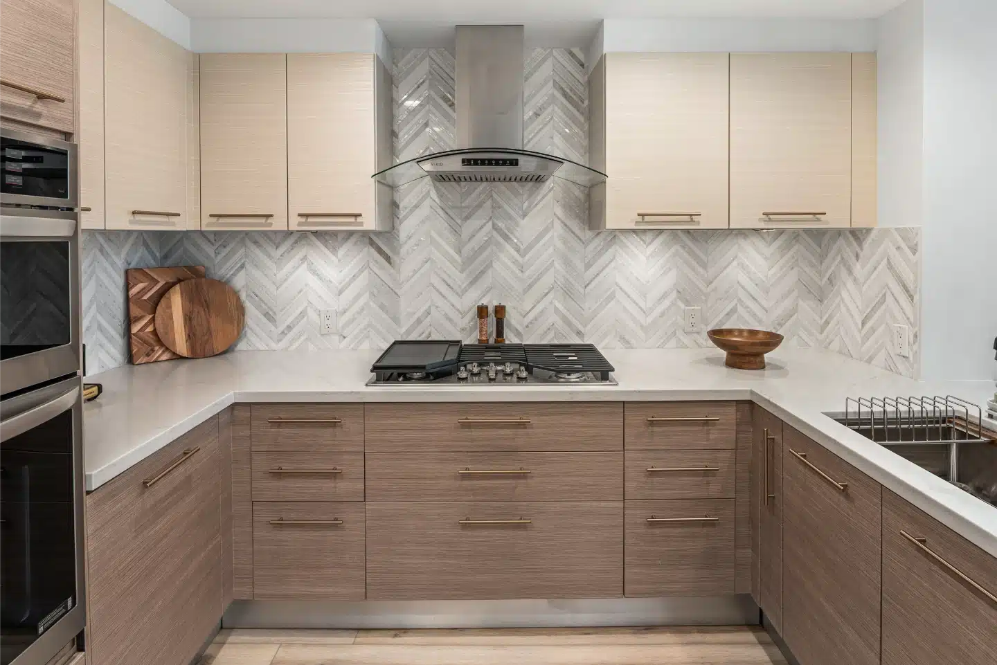 Condo remodel in Little Italy with two-tone cabinetry and a herringbone backsplash