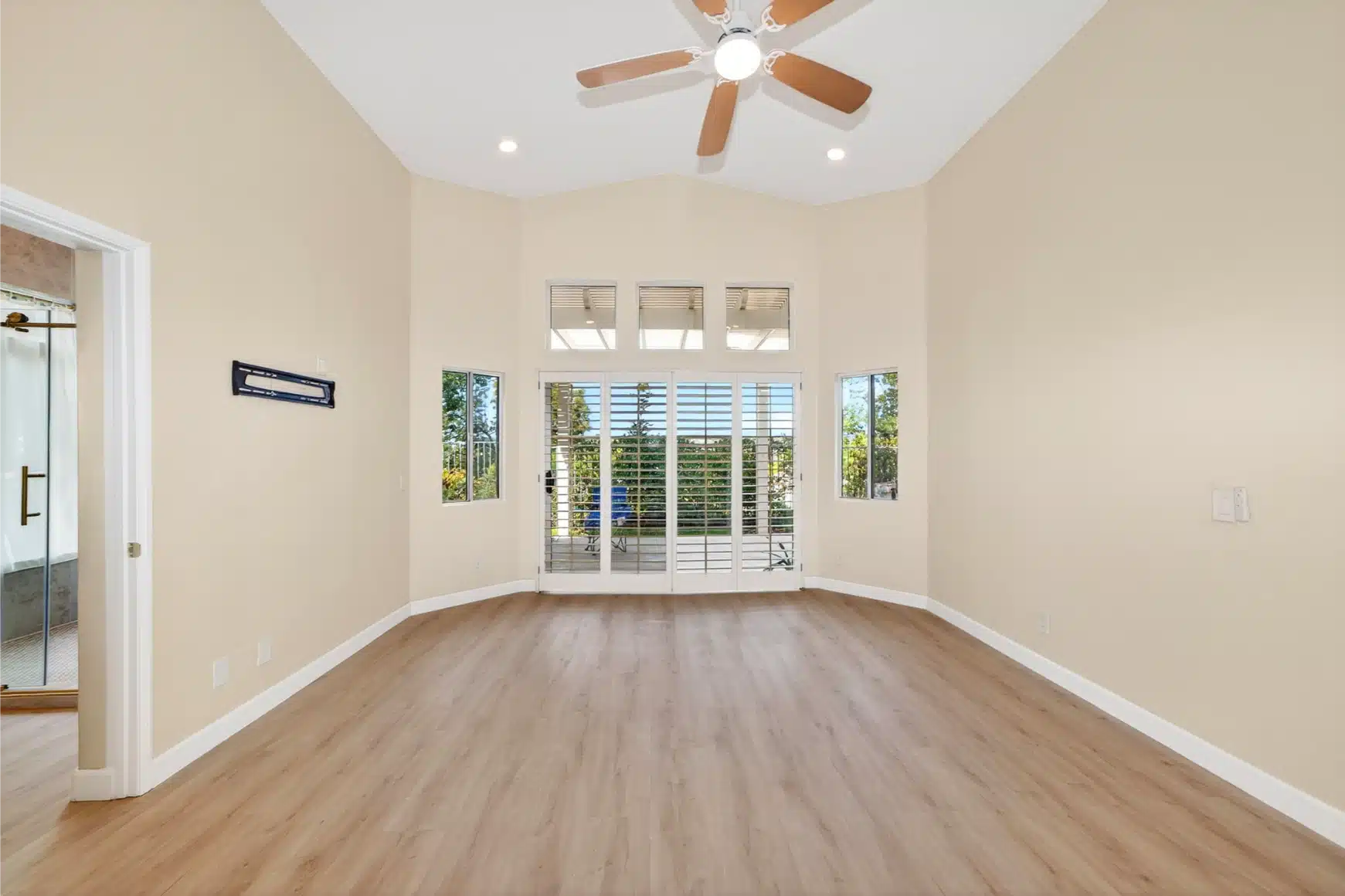 Bedroom with a ceiling fan and shuttered doors to the garden