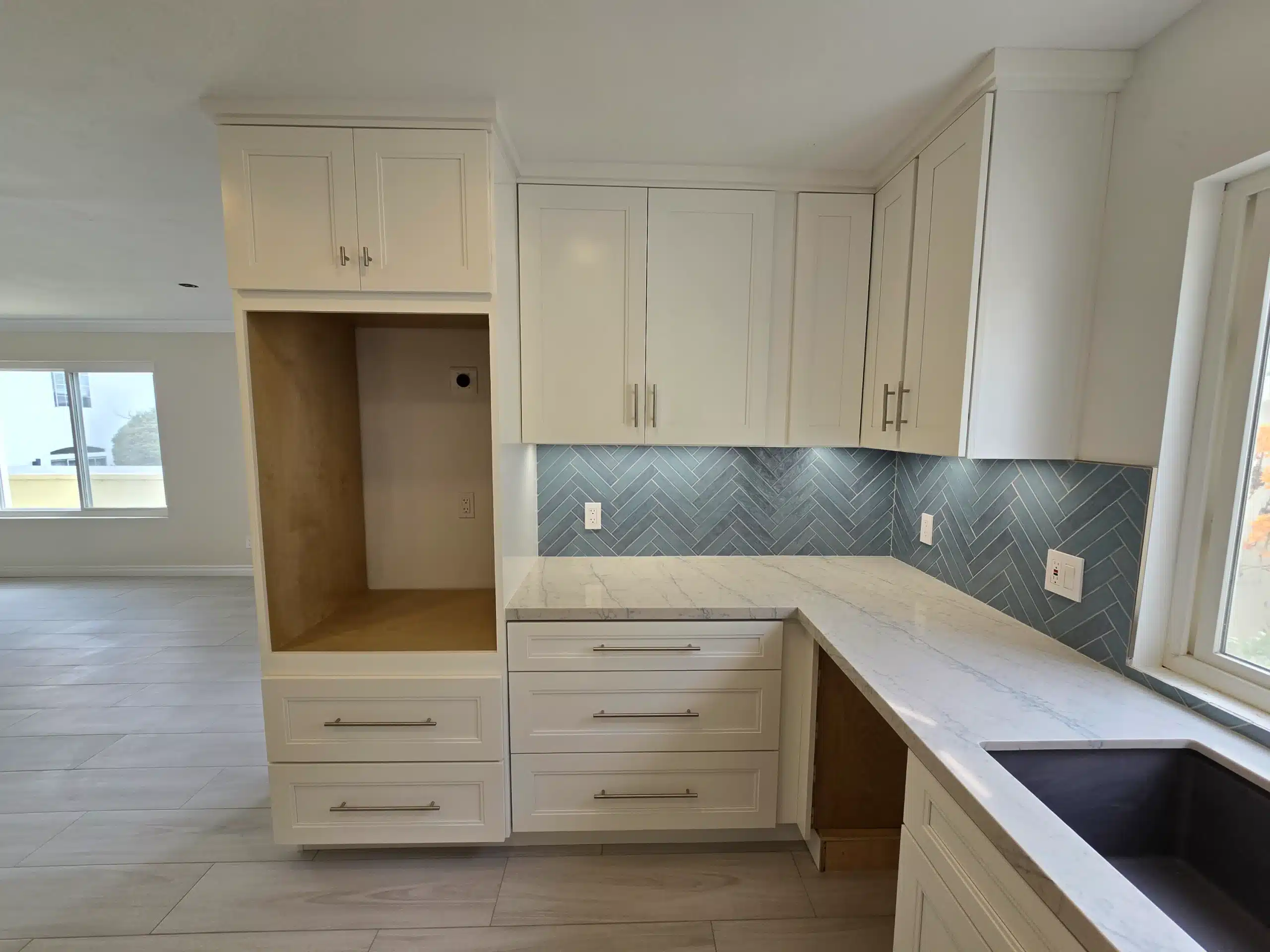 Encinitas kitchen with full-height shaker cabinetry, an integrated pantry column and marble-look quartz counters