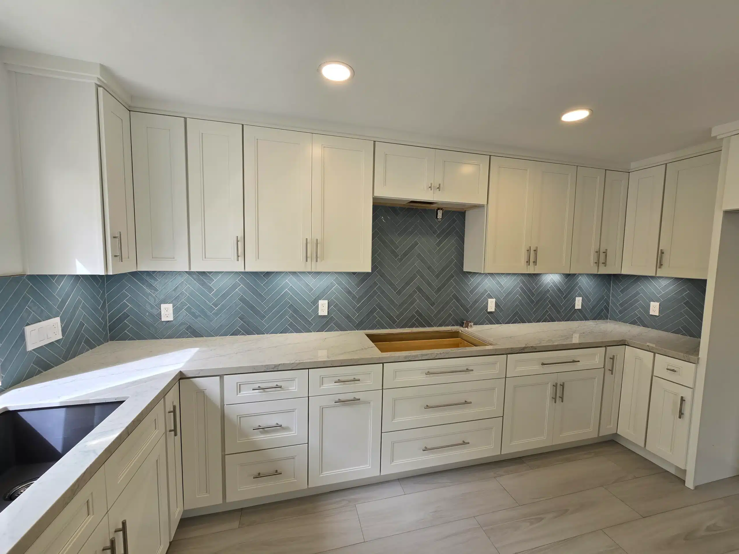 Kitchen remodel in Encinitas with white shaker cabinetry and a herringbone tile backsplash