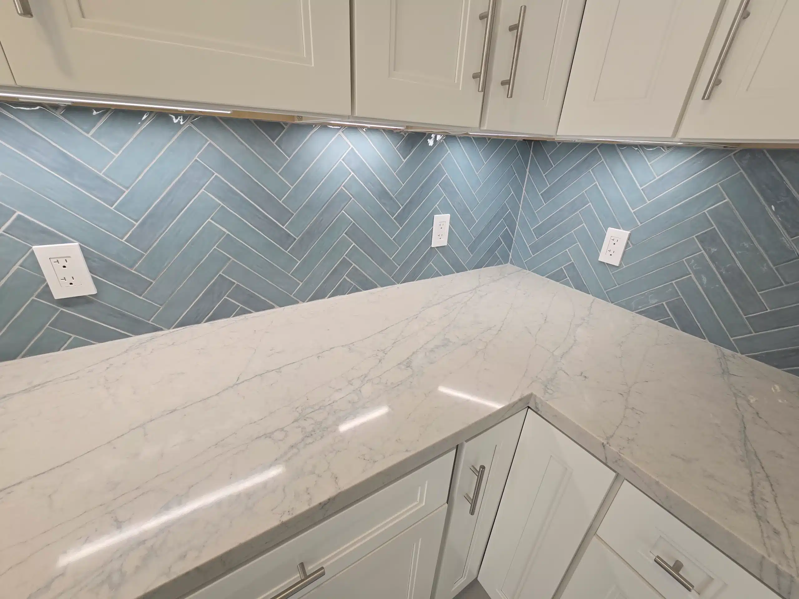 Completed Encinitas kitchen, with the herringbone backsplash meeting the quartz counter