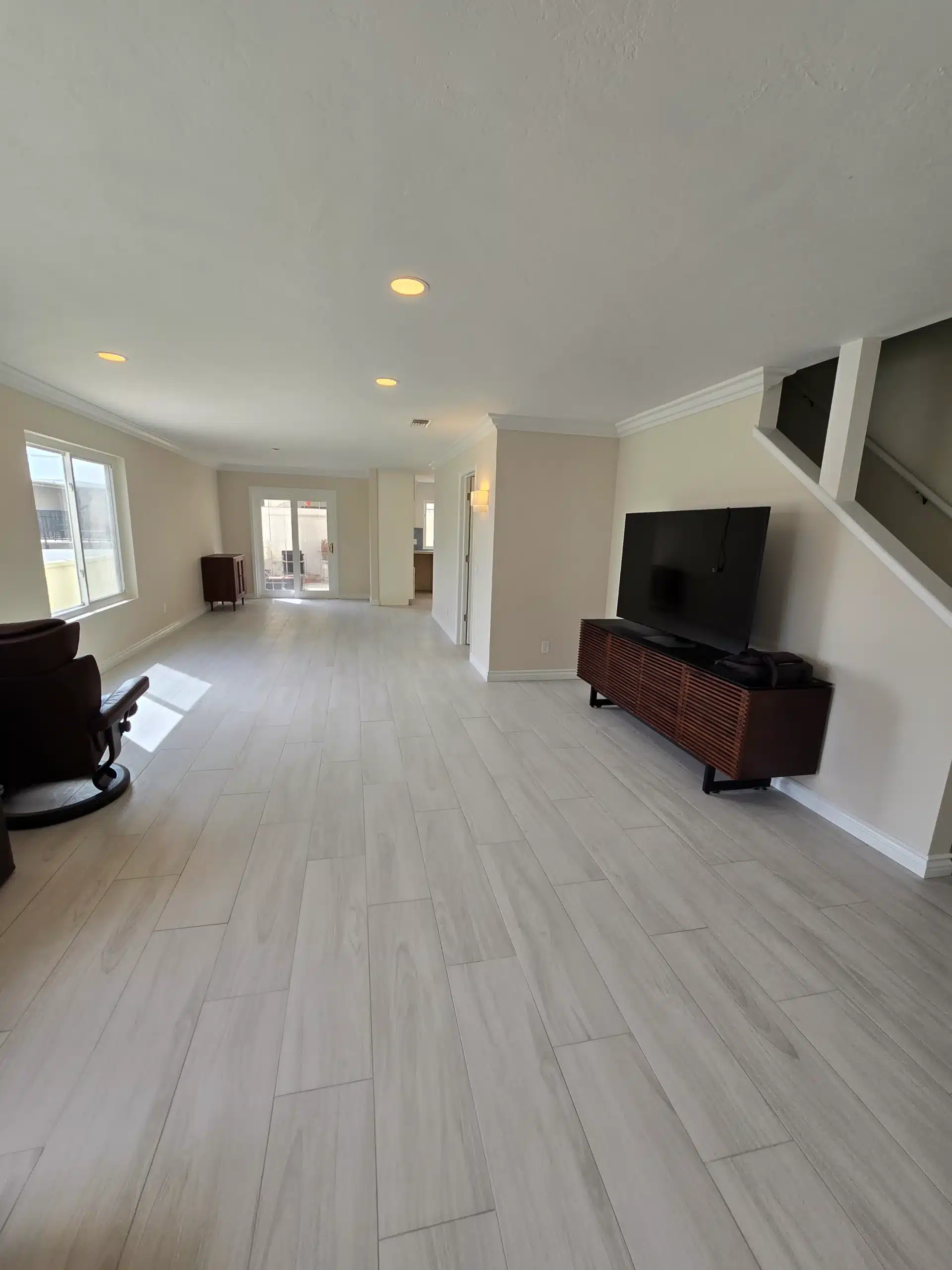 Open living area beside the kitchen with light wood-look plank flooring