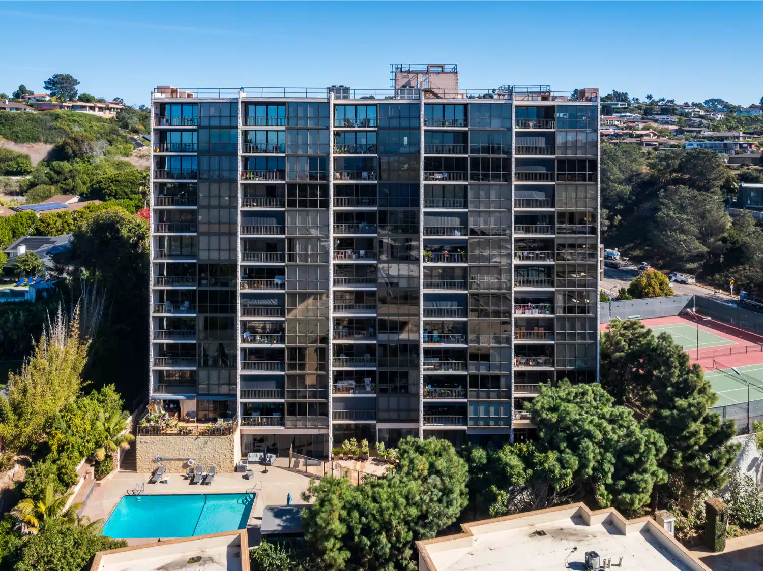 The La Jolla high-rise from the grounds, with the pool deck and mature palms