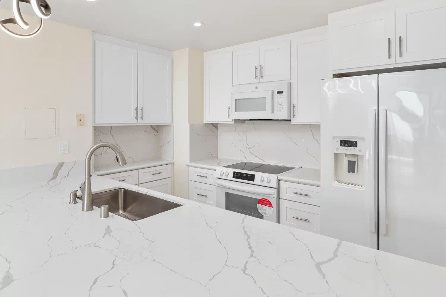 Marble-look counter and undermount sink beside the integrated oven