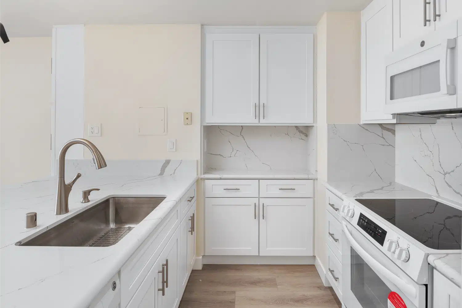 Cooktop and cabinetry run with a gooseneck tap at the window