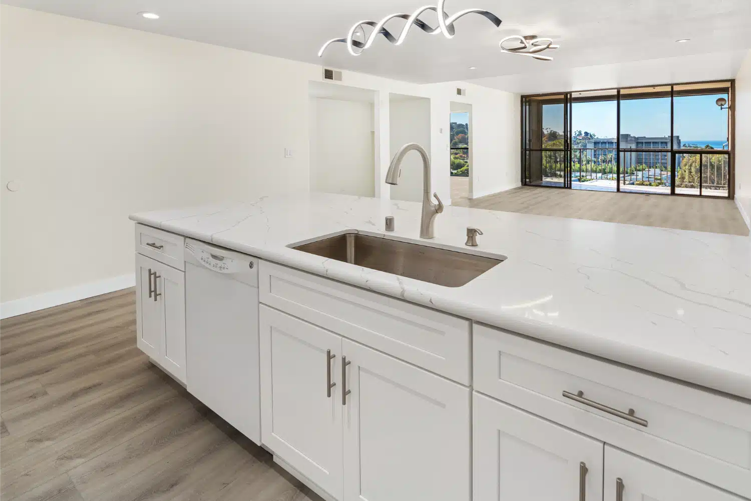 Kitchen island with an integrated sink, looking out through the window wall
