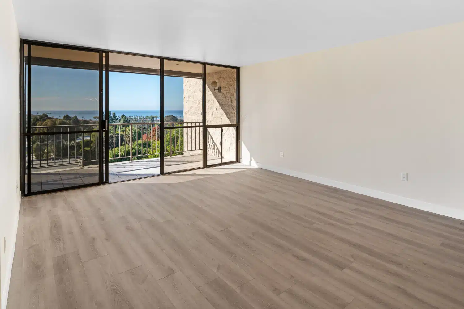 Living area with sliding balcony doors framing the coastal view