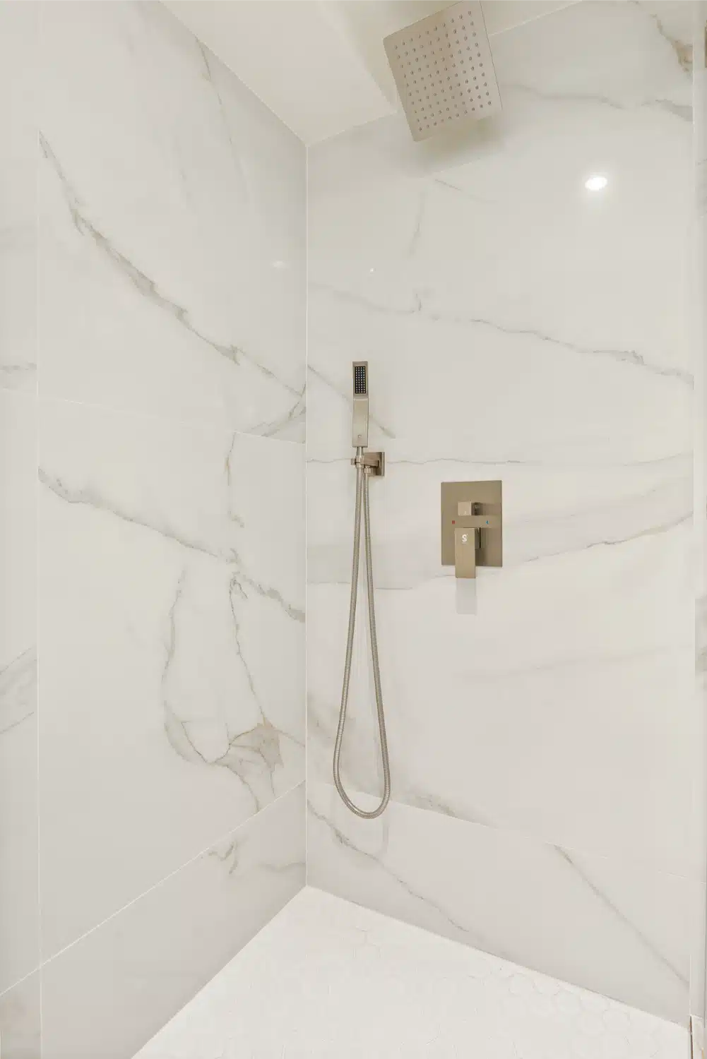 Large-format marble-look porcelain in the shower, with a handheld set
