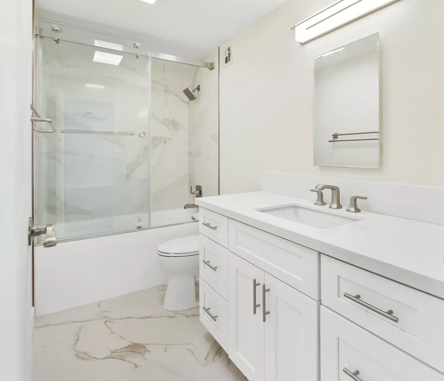 Completed bathroom with a tub, frameless glass panel and double vanity