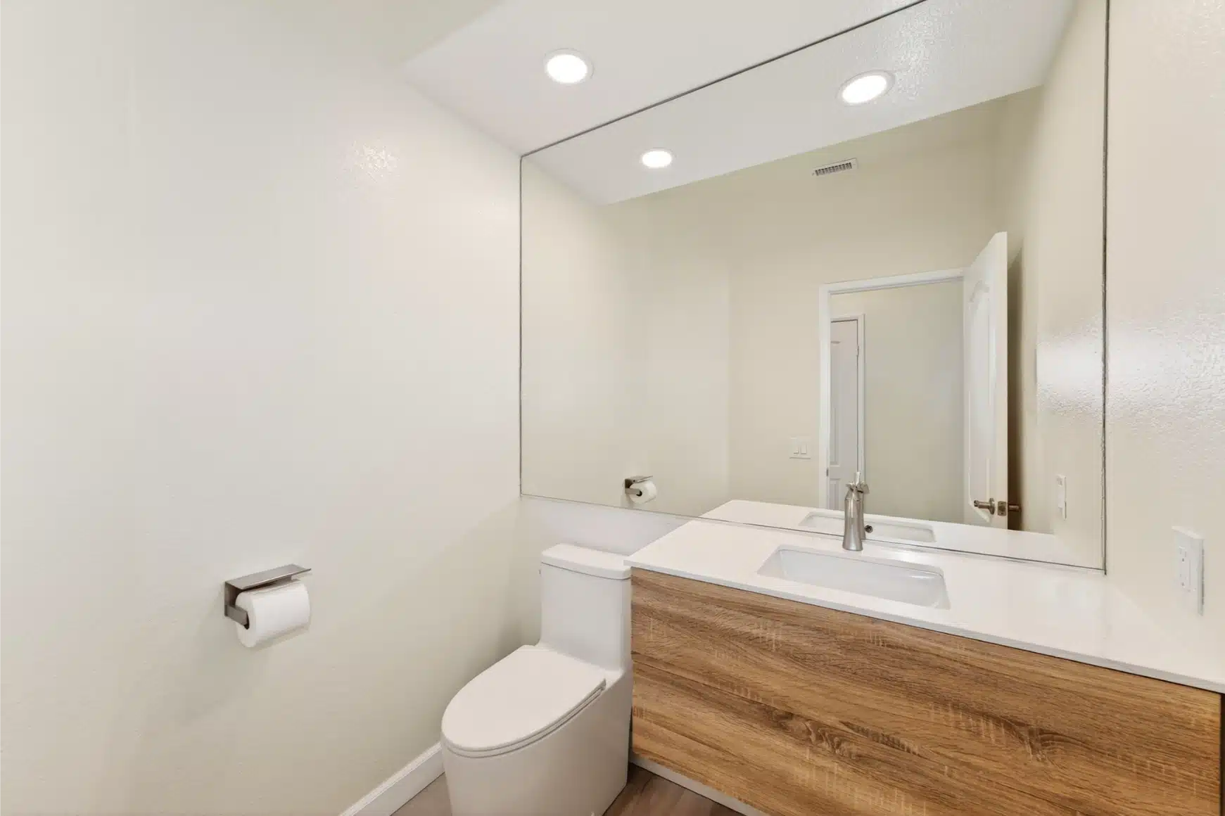 Third bathroom with a floating oak vanity and wide mirror