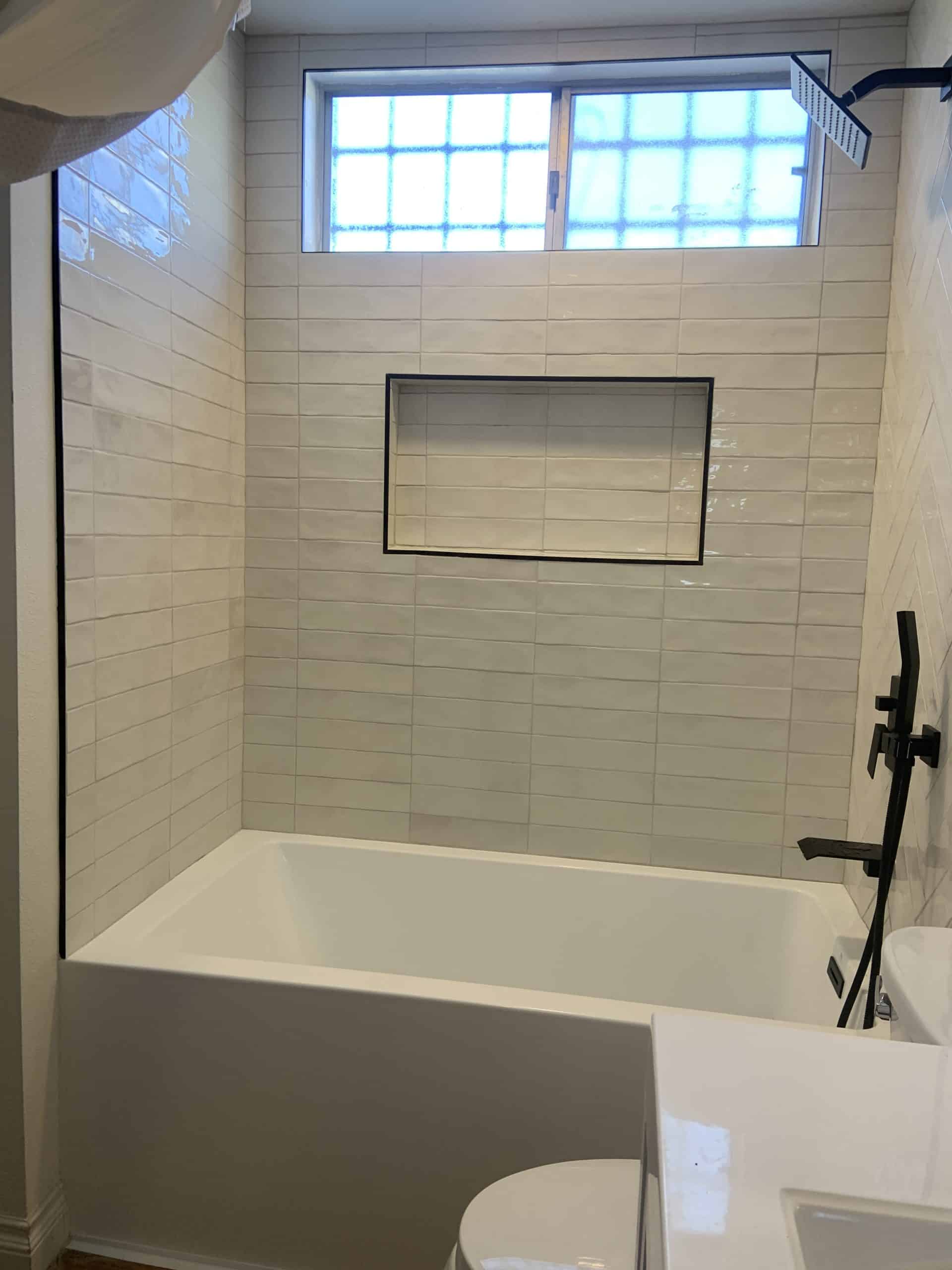 Matte black shower set and handheld mounted against the tiled surround