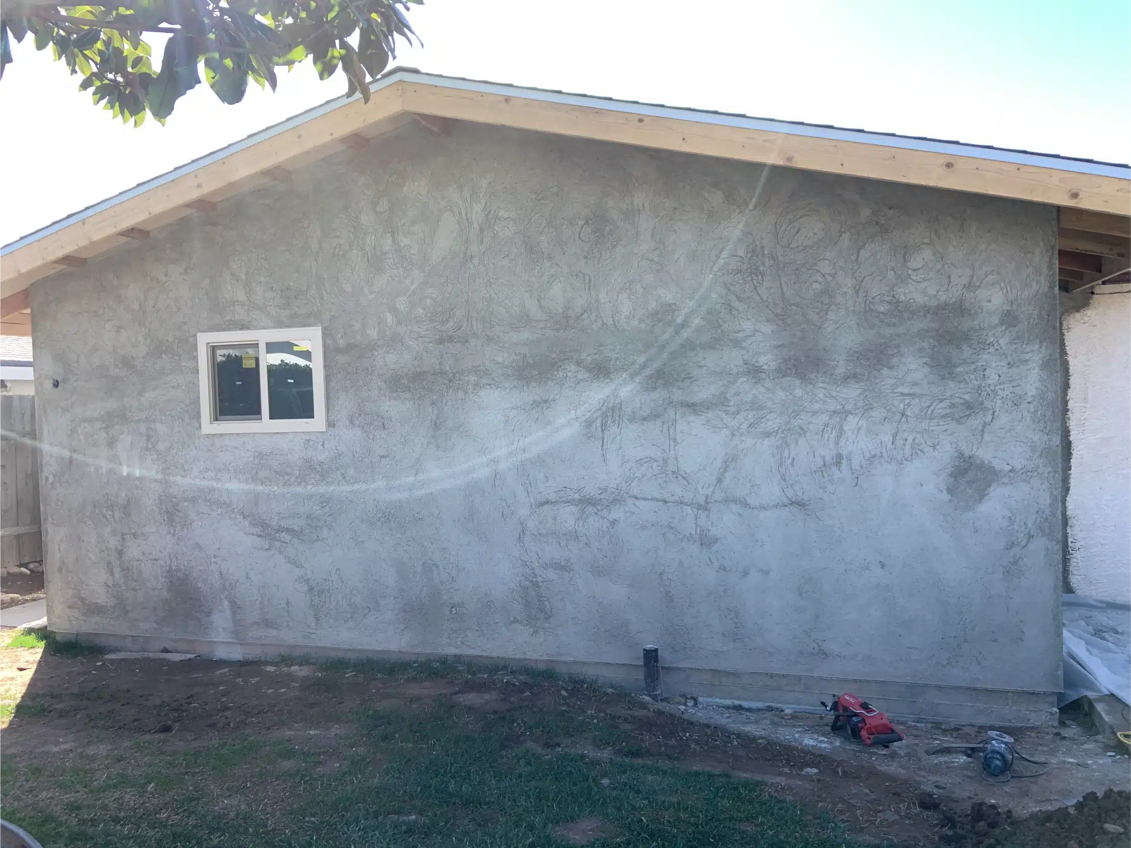 The addition rendered in stucco, matched to the existing elevation