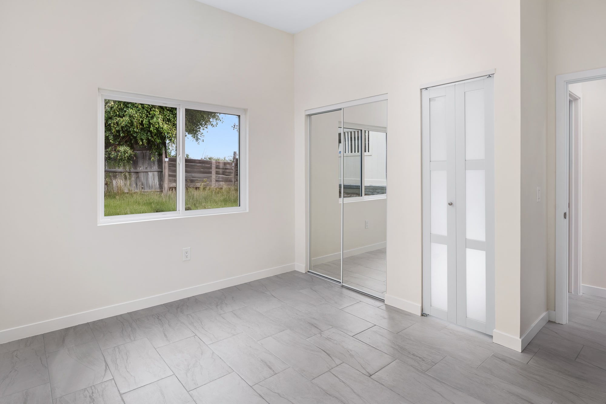 Living space of the finished 498 square foot ADU, with plank flooring and a window to the yard