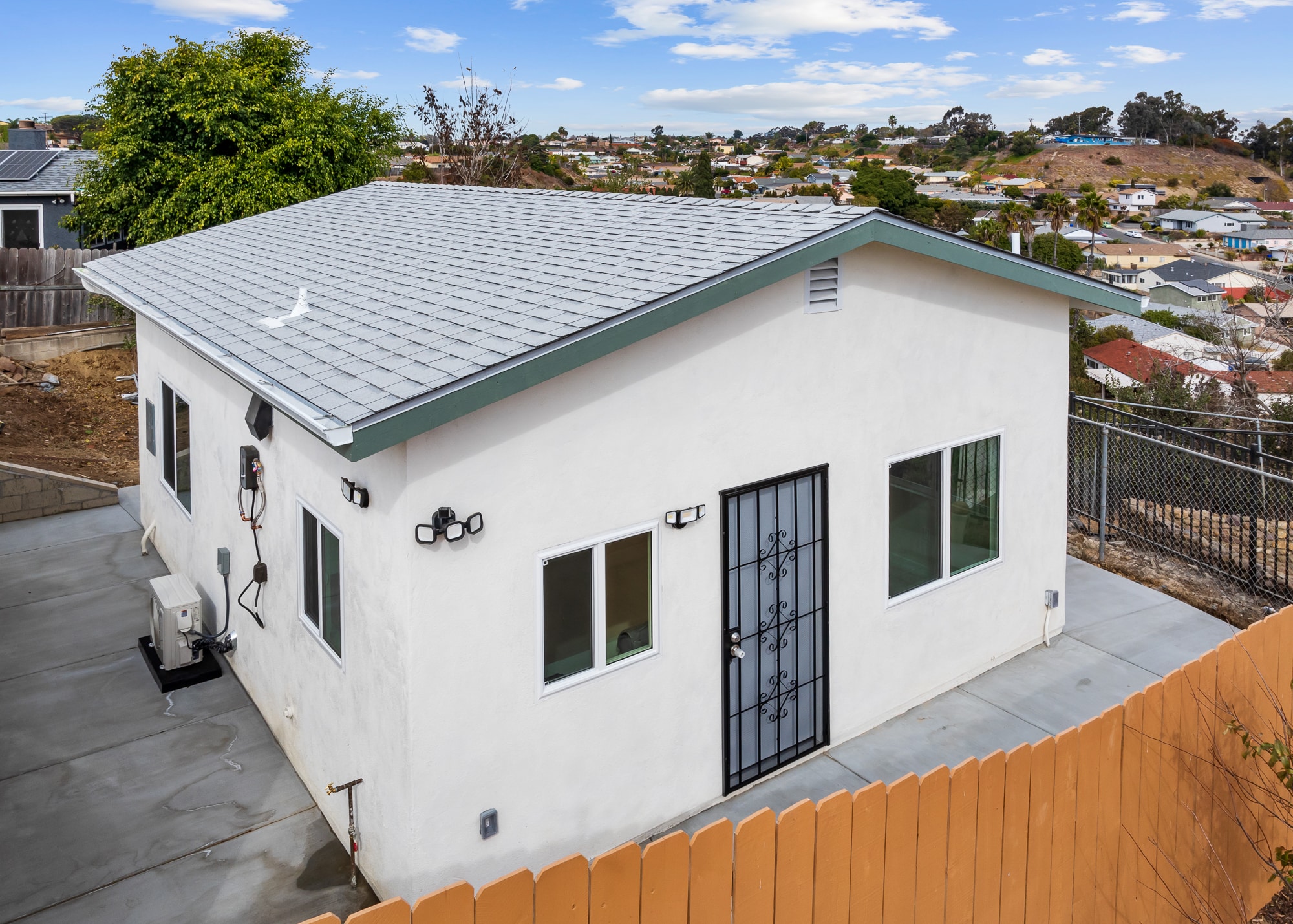 The completed ADU from the side, showing the metal roof and stucco finish
