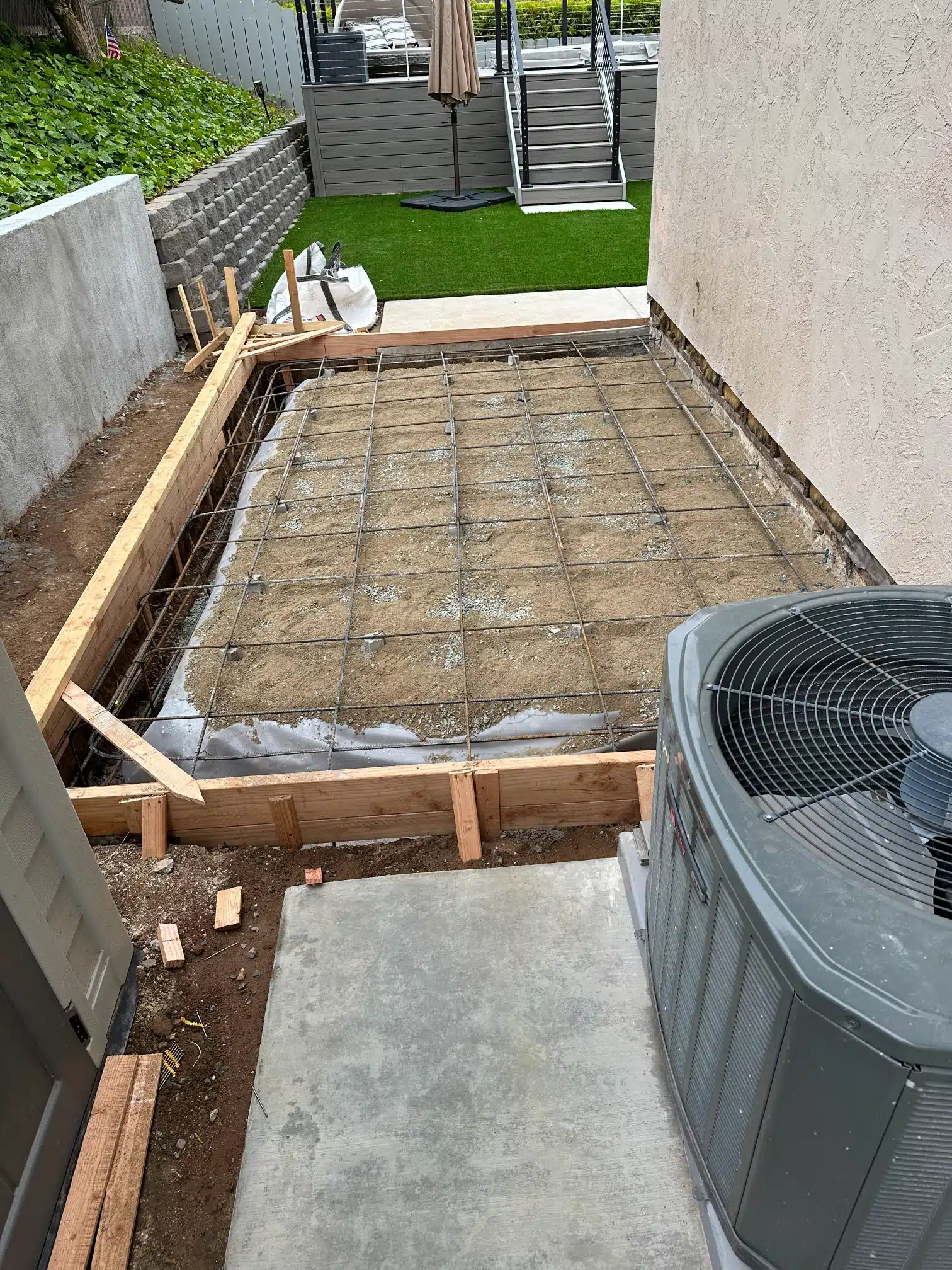 Forms and reinforcement set out for the new slab beside the house