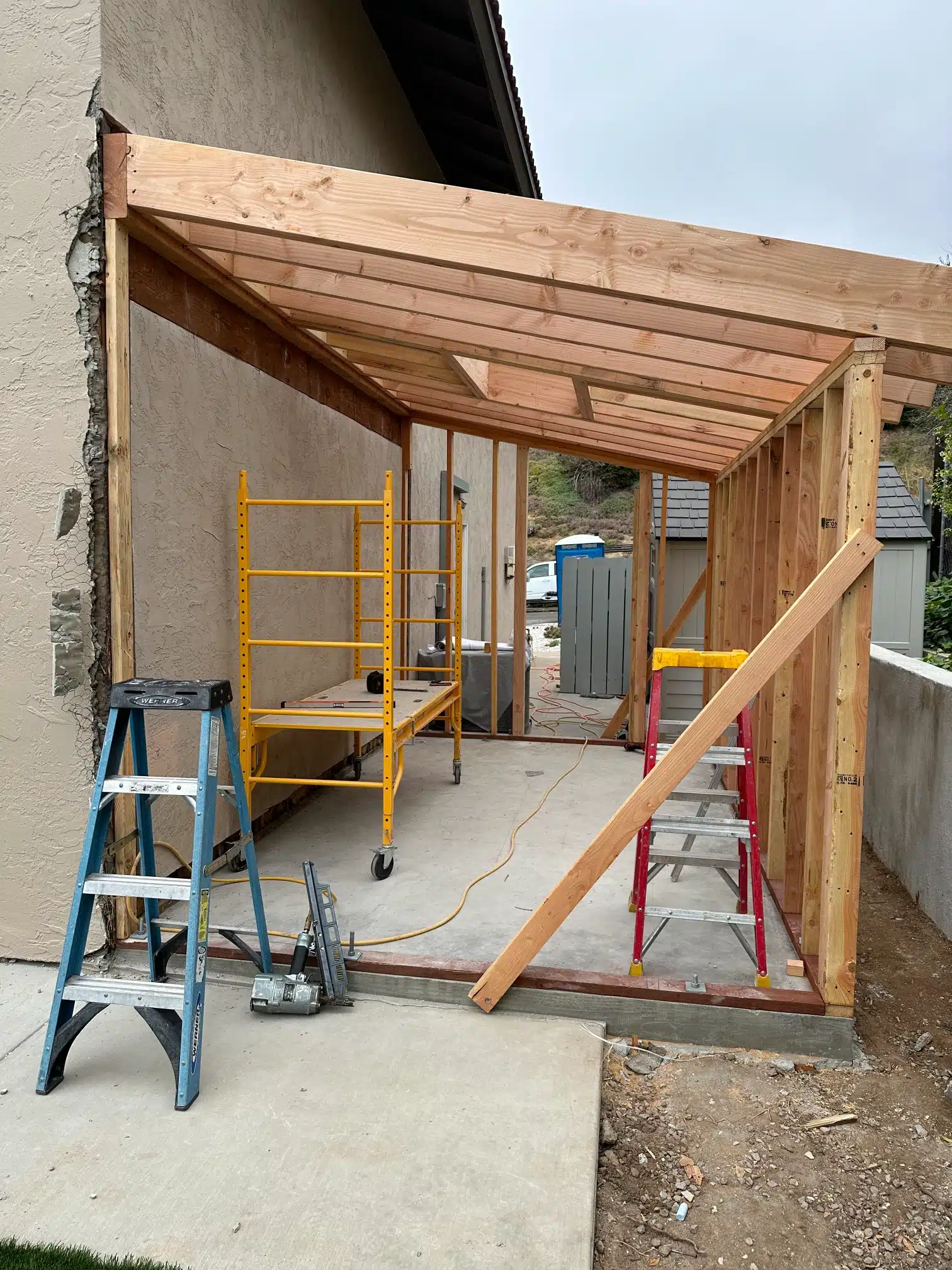 Beam and framing raised against the existing house during the addition