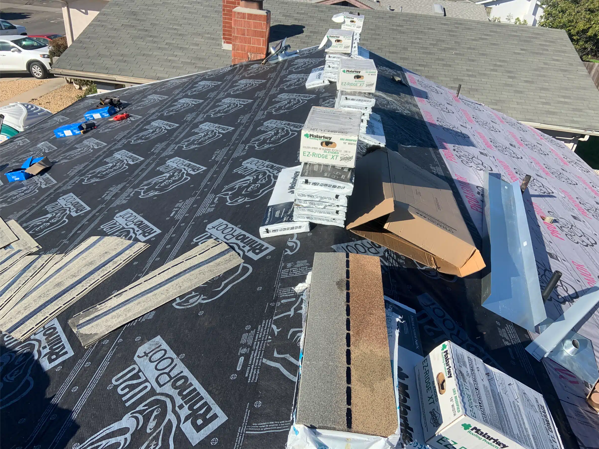New roof sheathing with shingle bundles staged across it