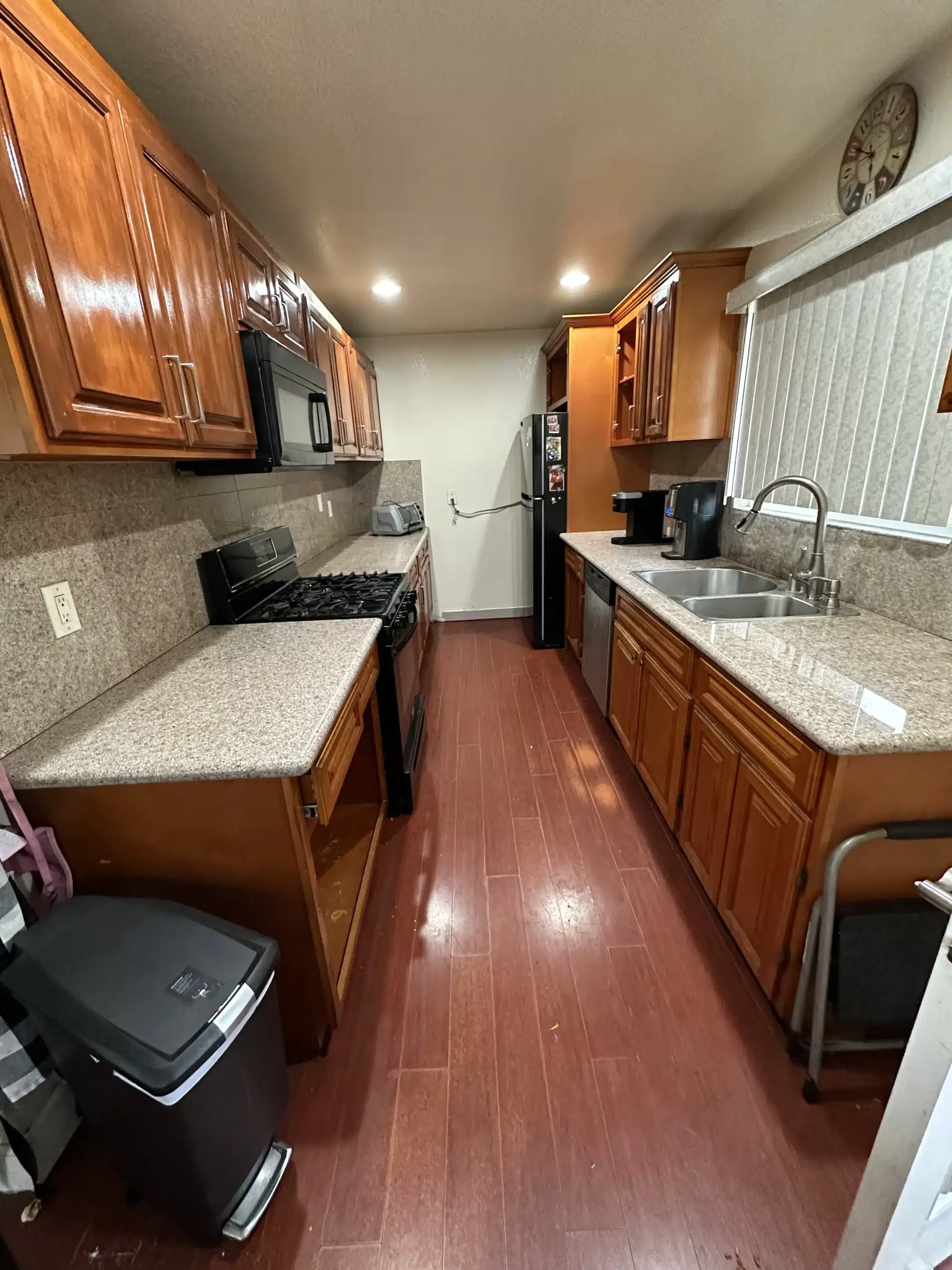 The San Diego galley kitchen before the remodel, with dark stained cabinetry and beige laminate counters