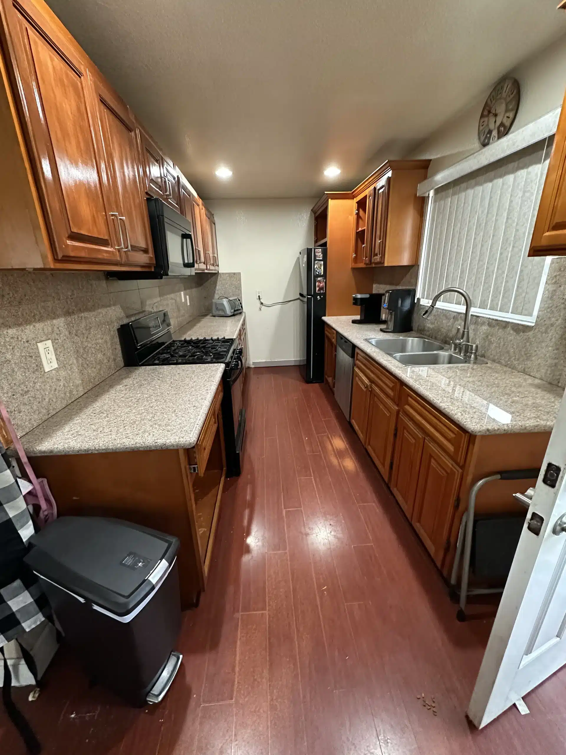 The original galley kitchen from the opposite end, showing dark cabinetry along both runs