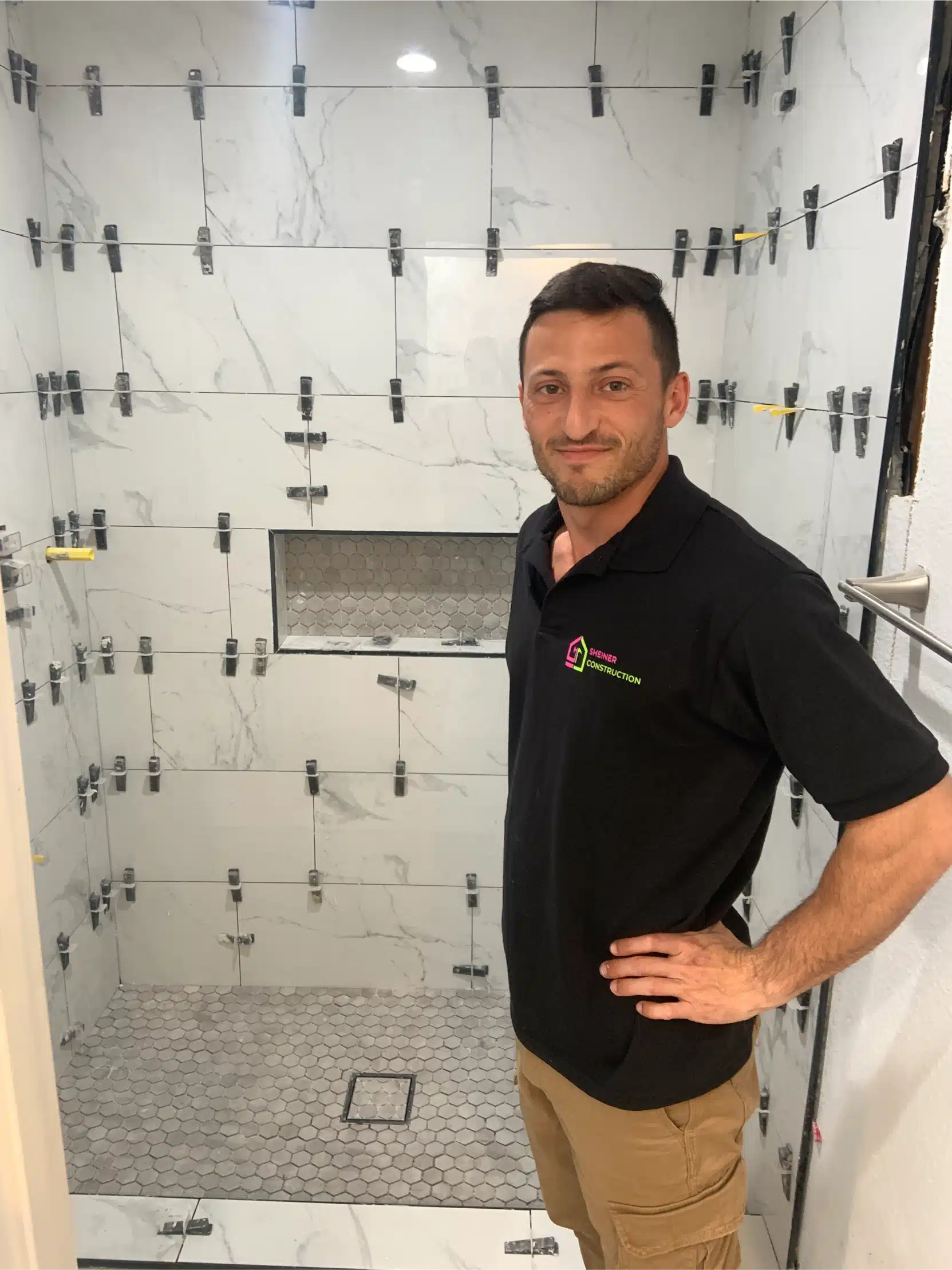 The shower fully tiled with levelling clips still in place