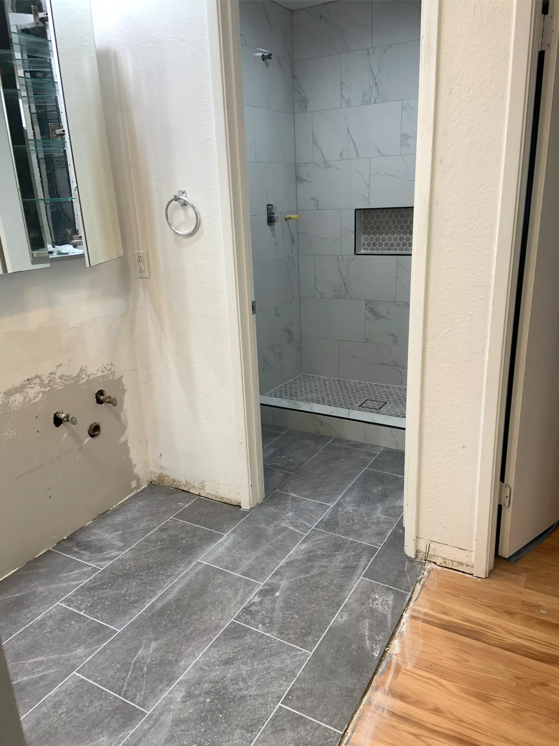 Plank-format floor tile run through the bathroom to the doorway