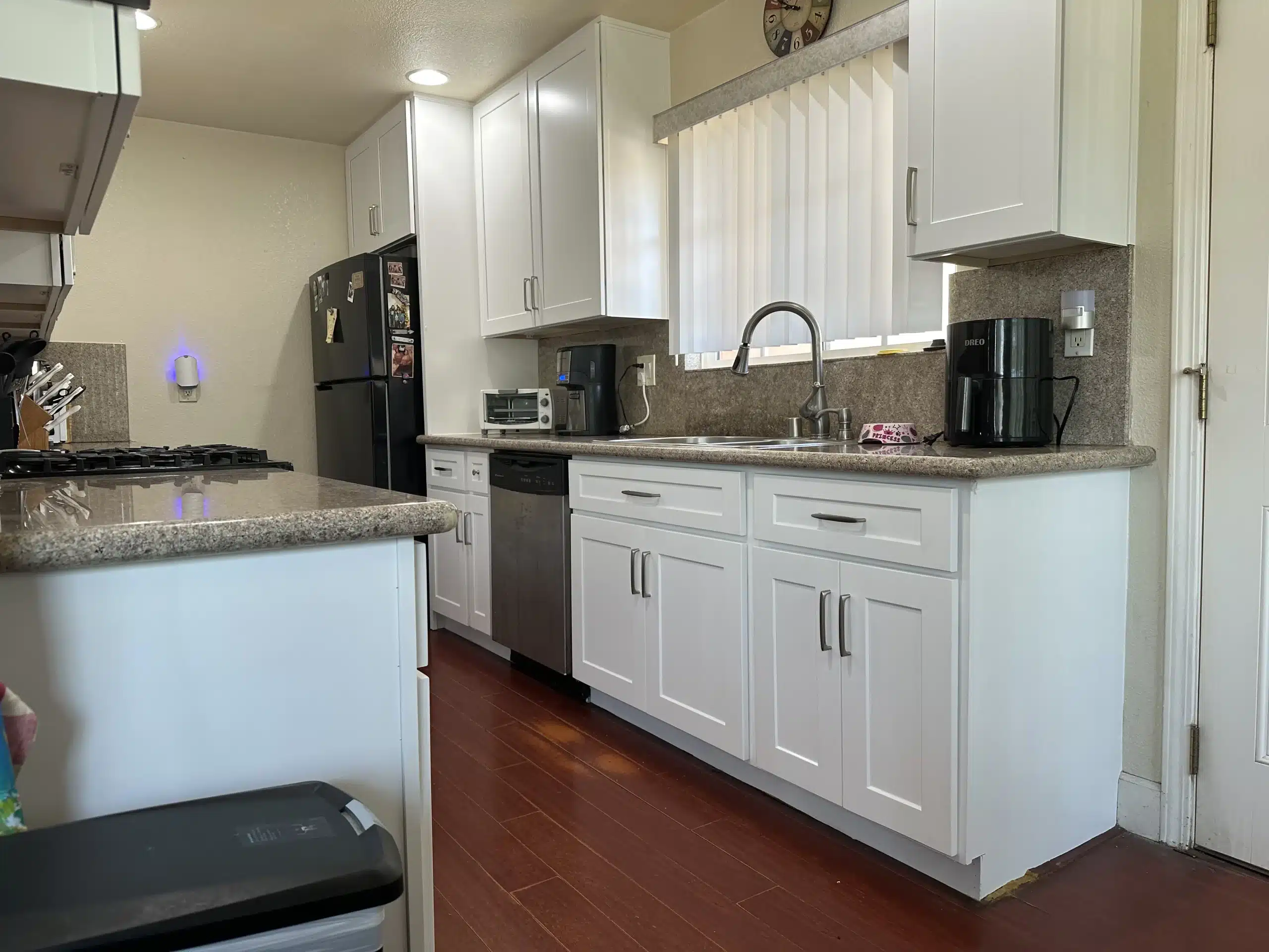 White shaker cabinetry and stone-look counters beside the refrigerator