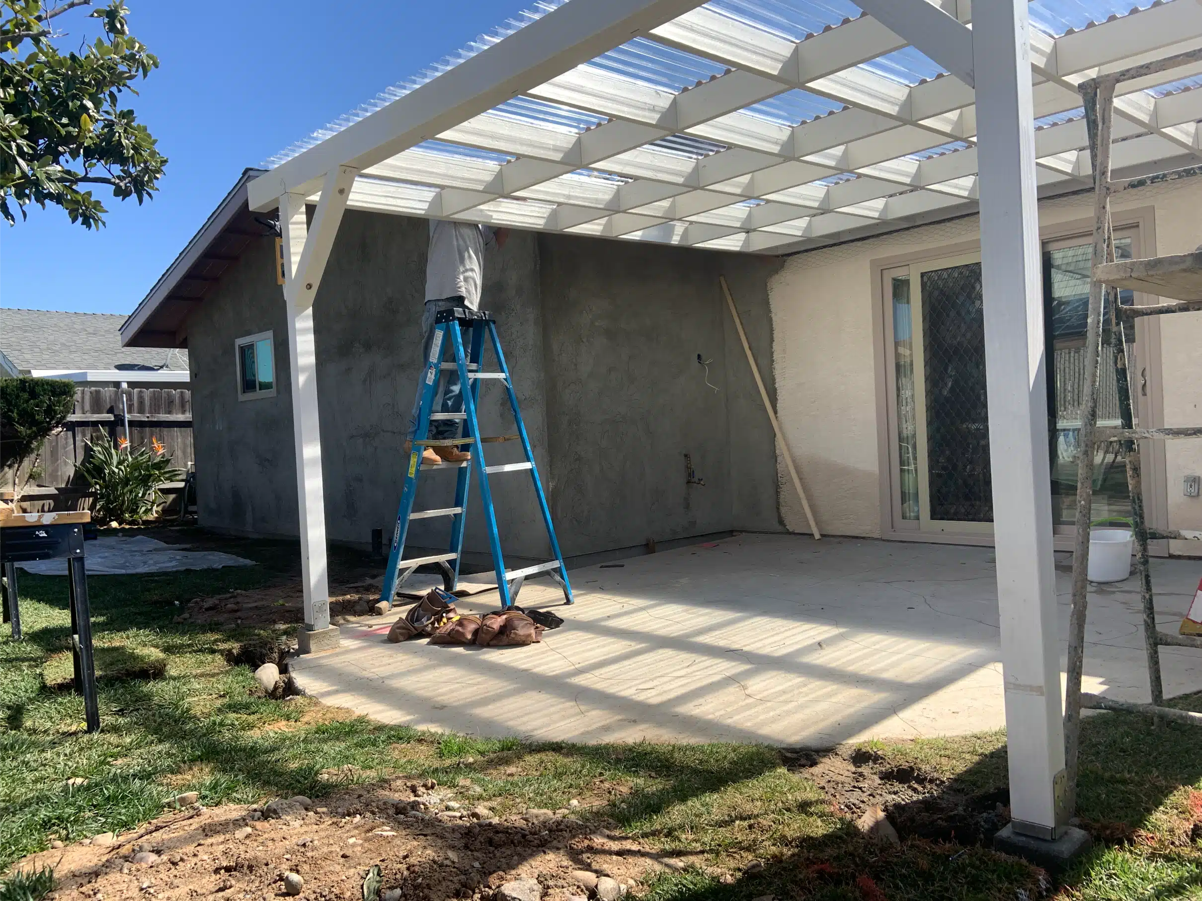 New covered patio structure and concrete alongside the addition