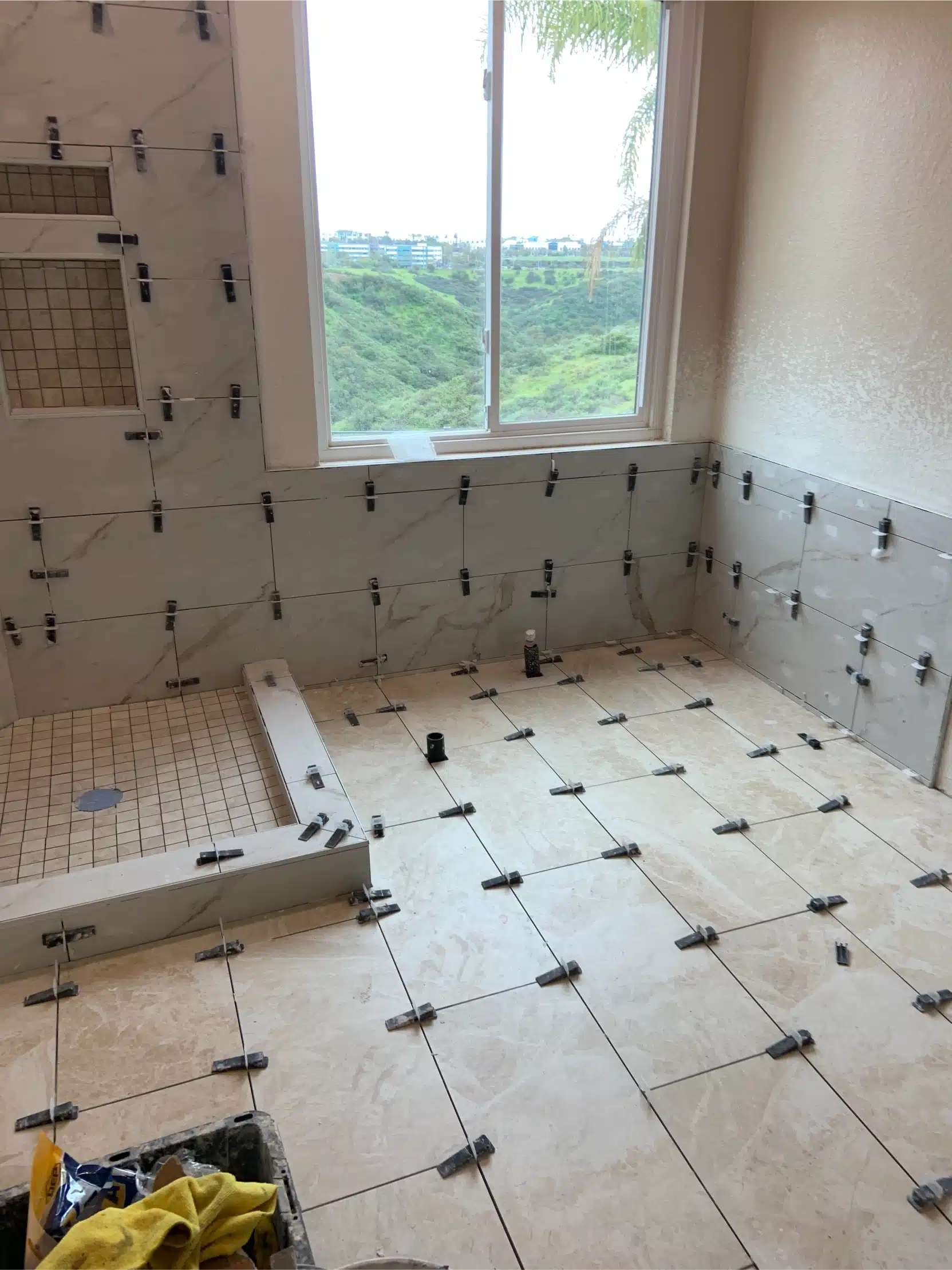 Floor tile set out with spacers across the bathroom