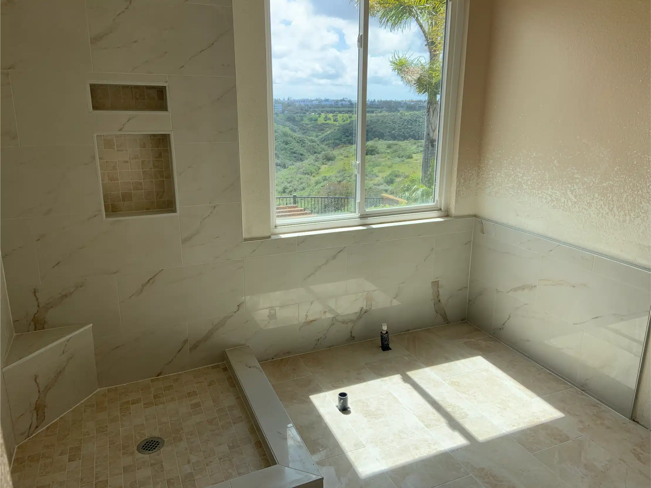 The shower walls tiled with the niches formed and the window trimmed