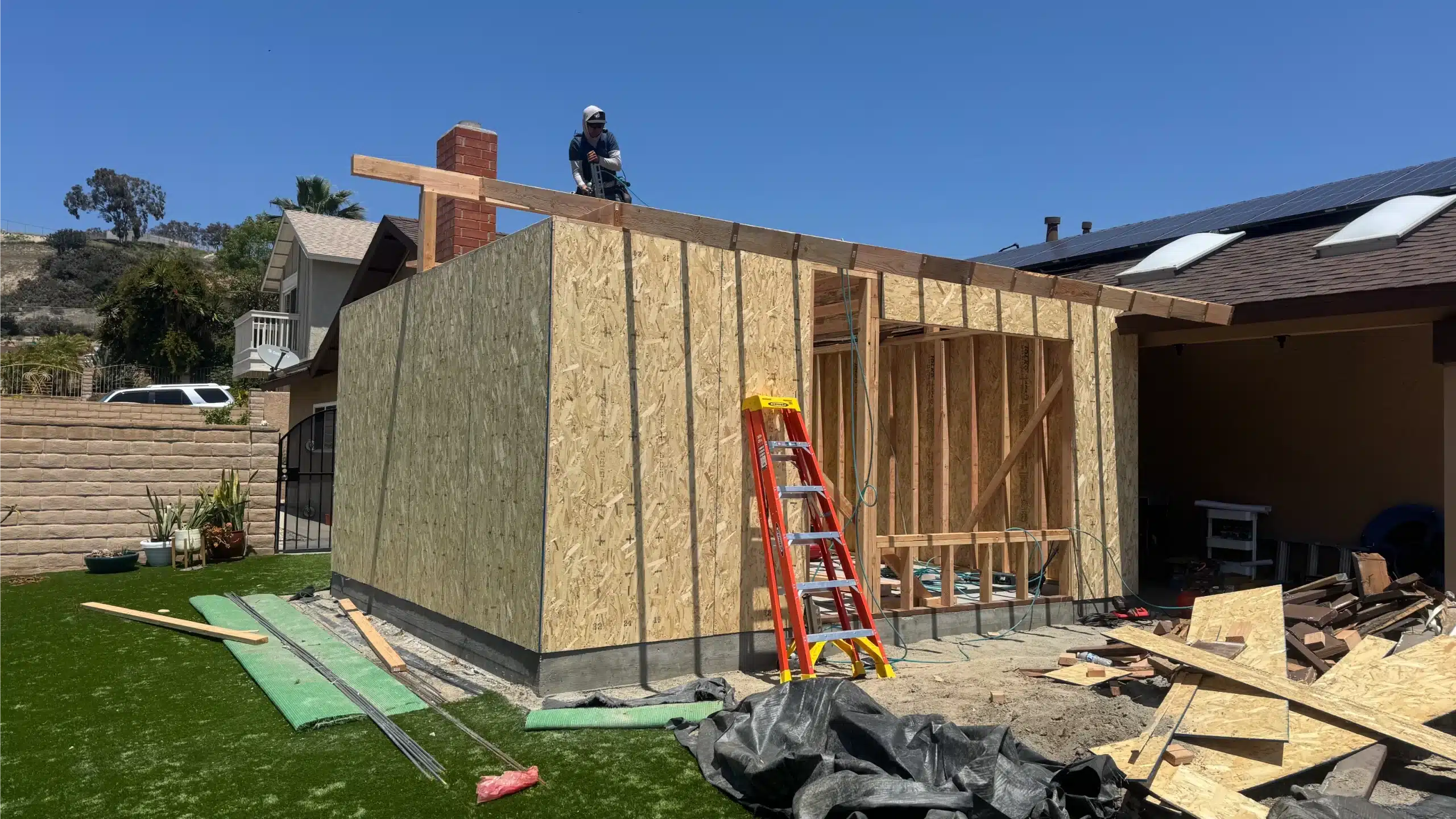 The addition framed and part-sheathed with the roof structure going on