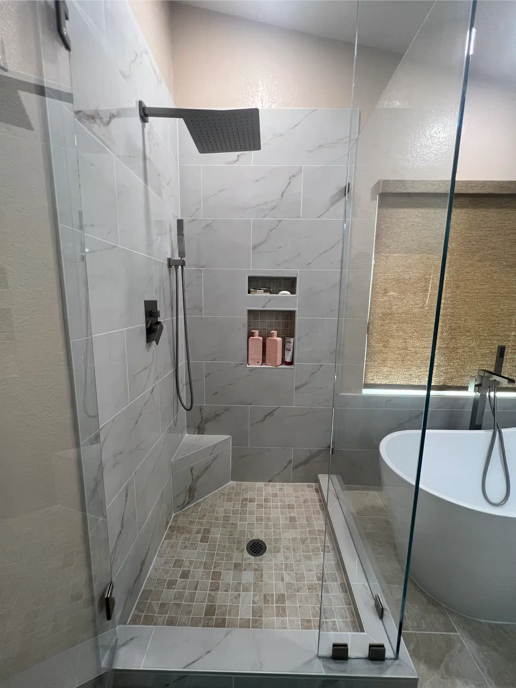The curbless shower with matte black fixtures and a linear drain