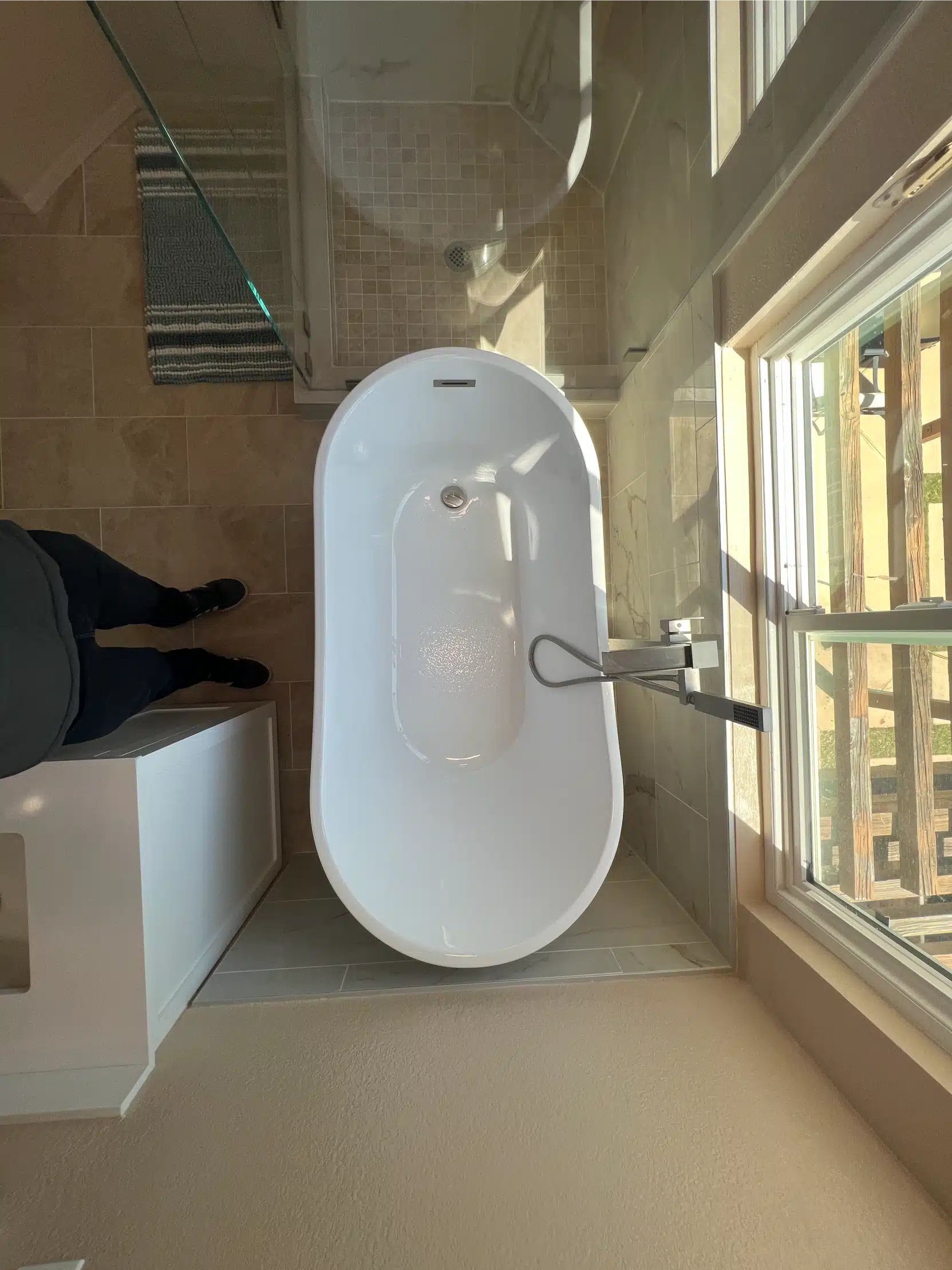 The freestanding tub set beneath the window in the completed bathroom
