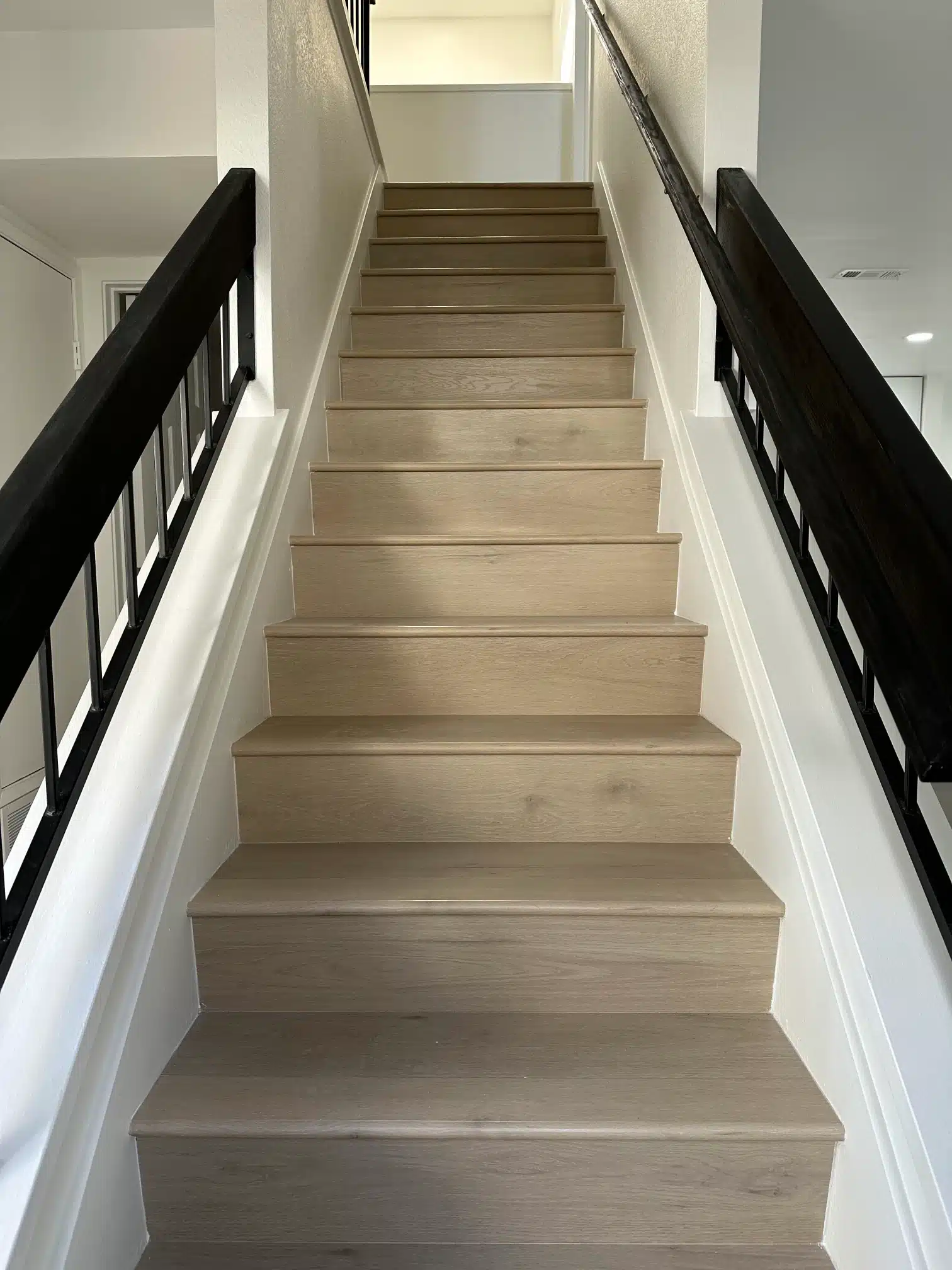 The rebuilt staircase with pale oak treads and a slim black railing