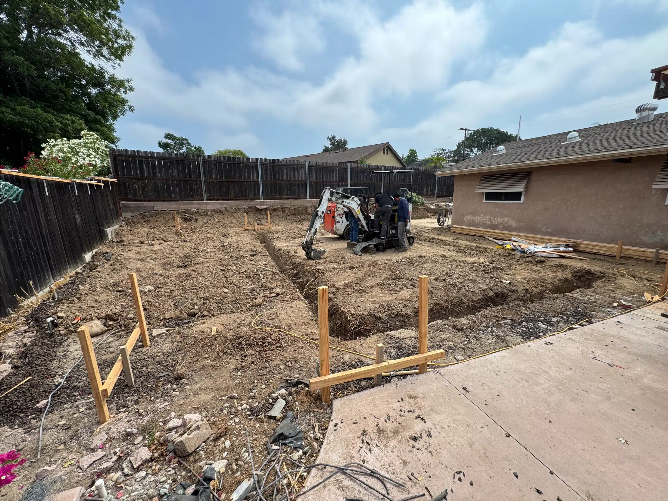 Rear yard excavated and set out with formwork stakes before the ADU foundation was poured