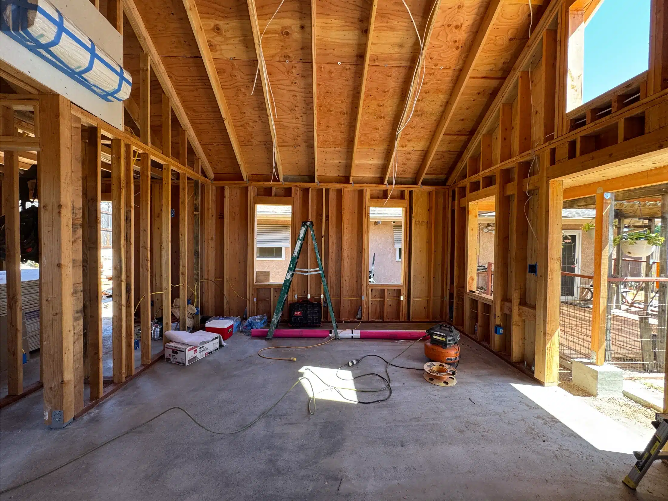 Interior of the ADU framed open, with exposed rafters and windows installed