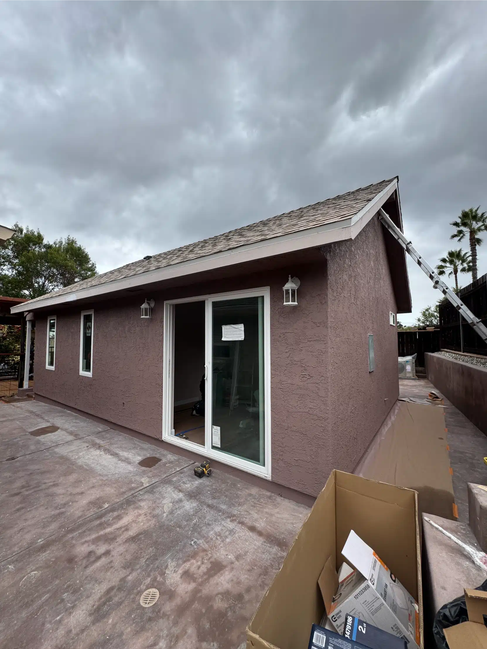 The completed ADU exterior in stucco with a sliding glass door