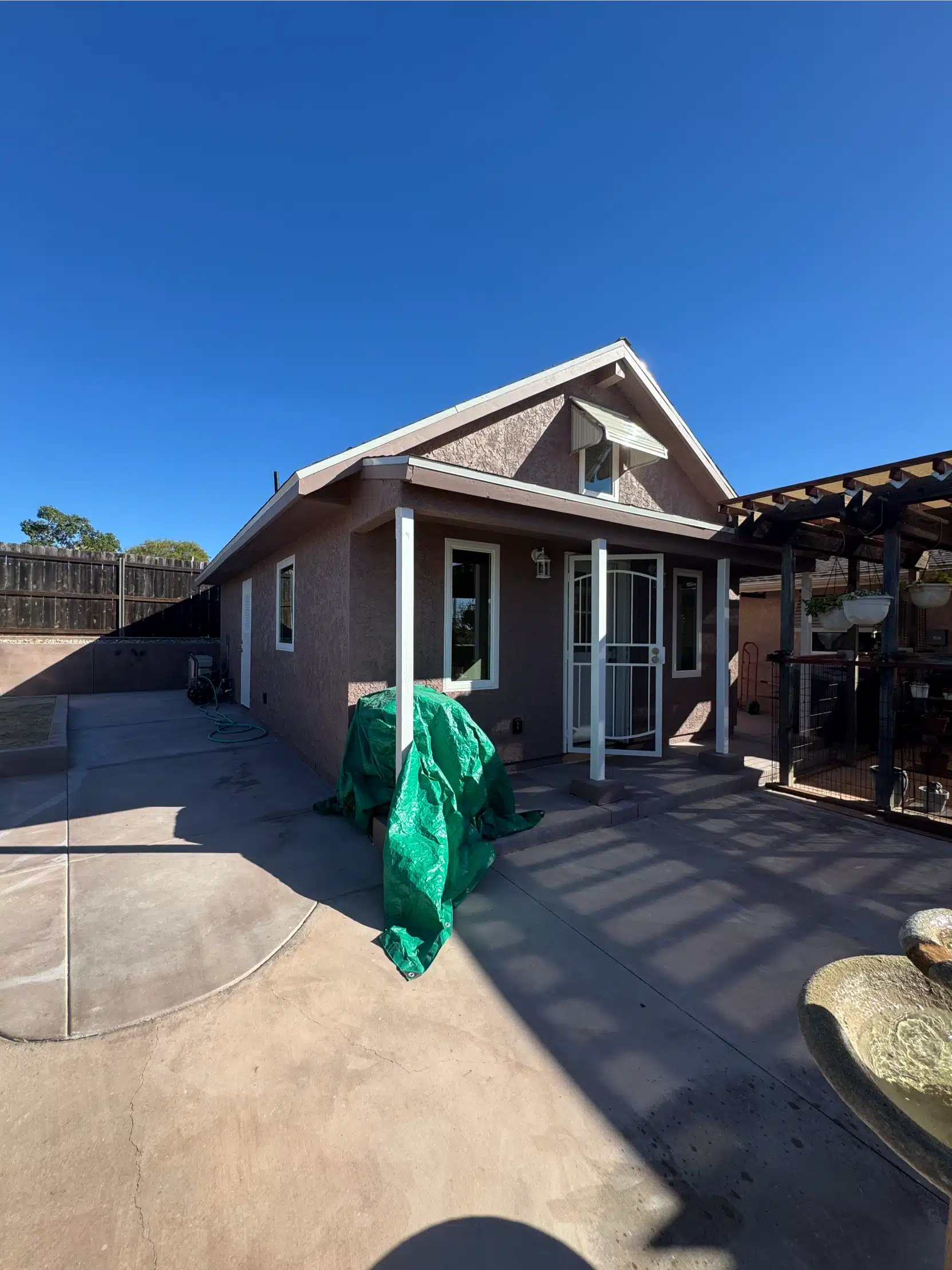 The completed ADU from the yard, with the covered entry and paving
