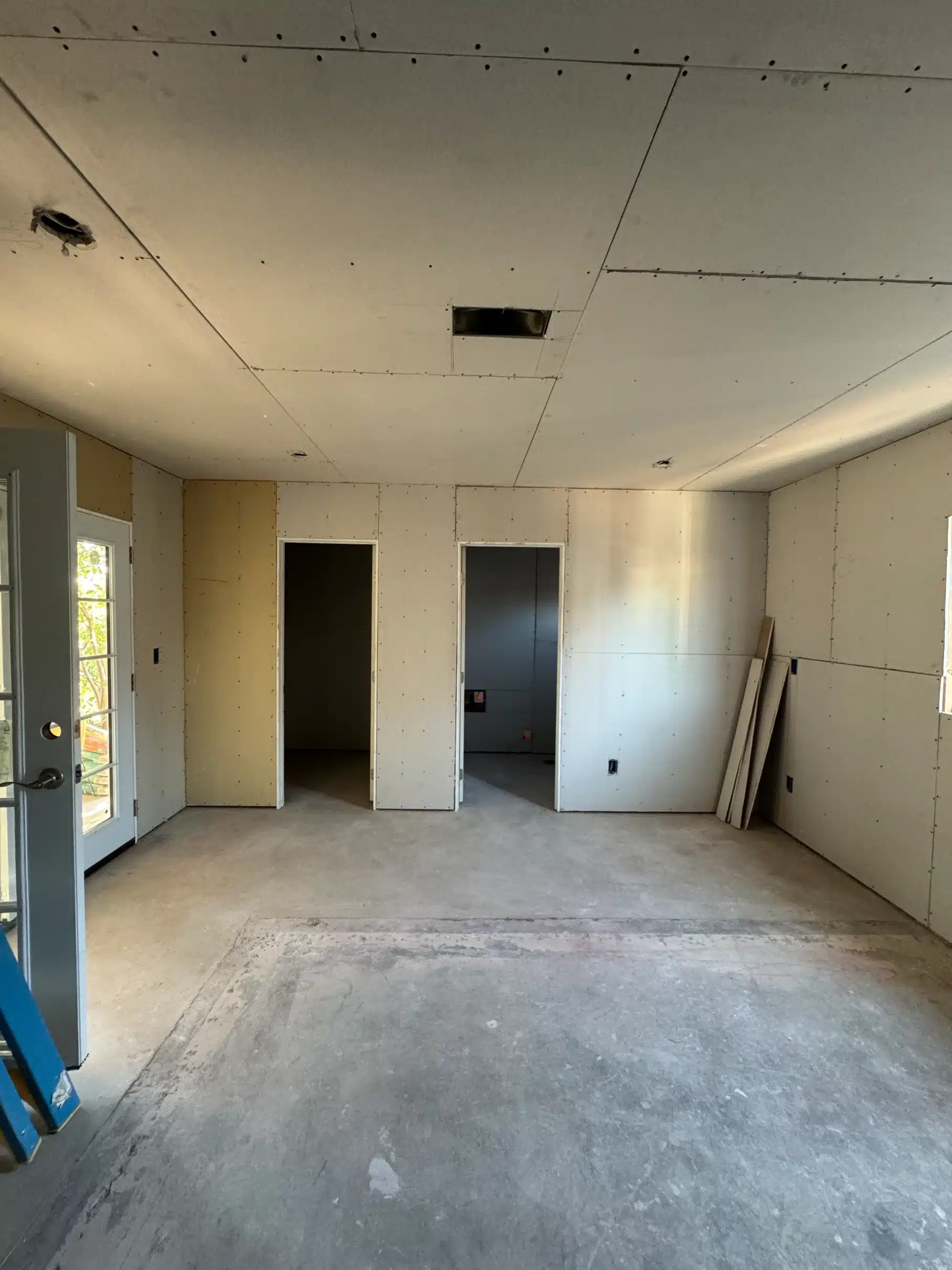 The addition drywalled and closed in, with the slab still exposed