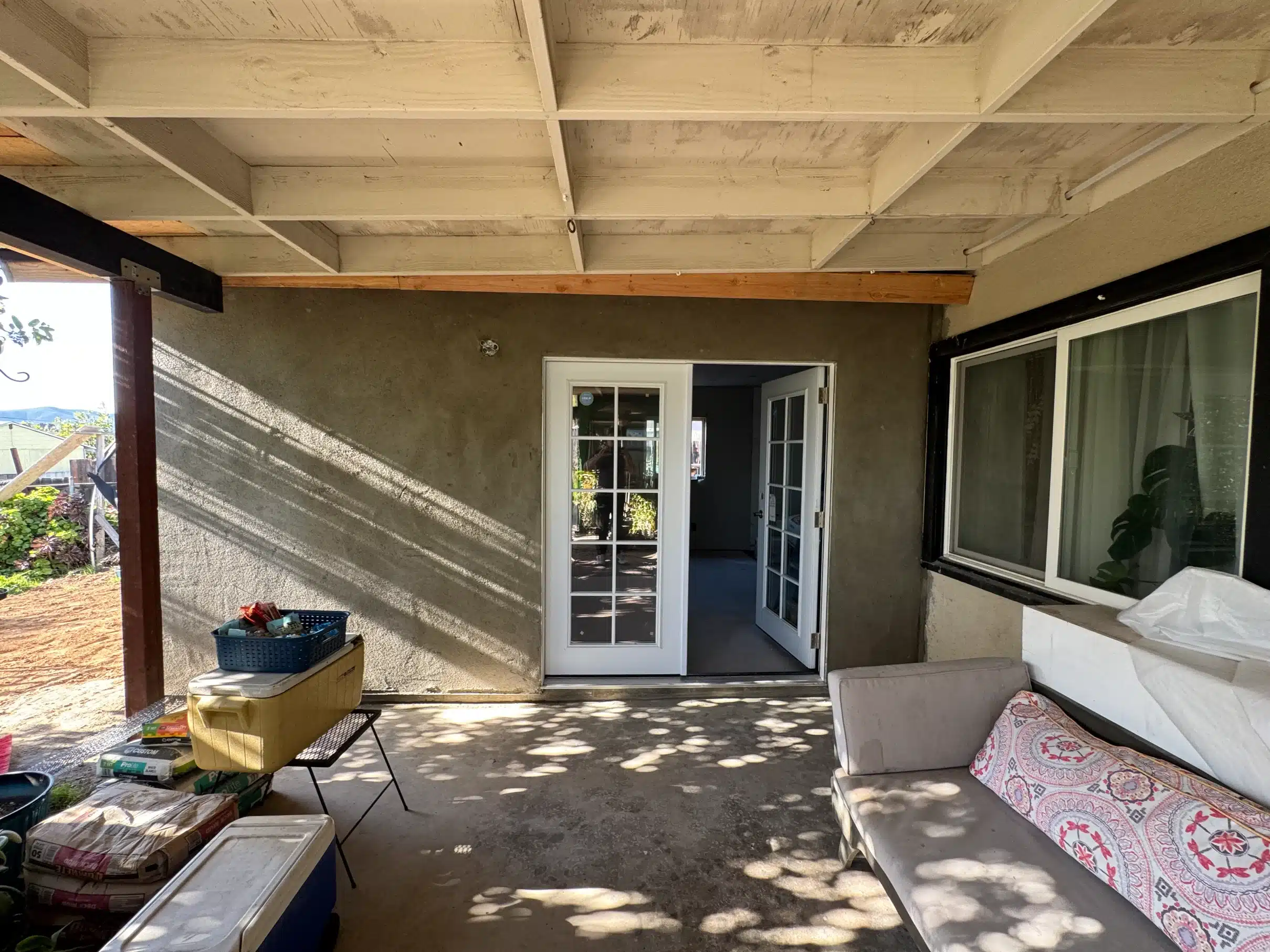 Covered patio under construction with the beam set and stucco going on