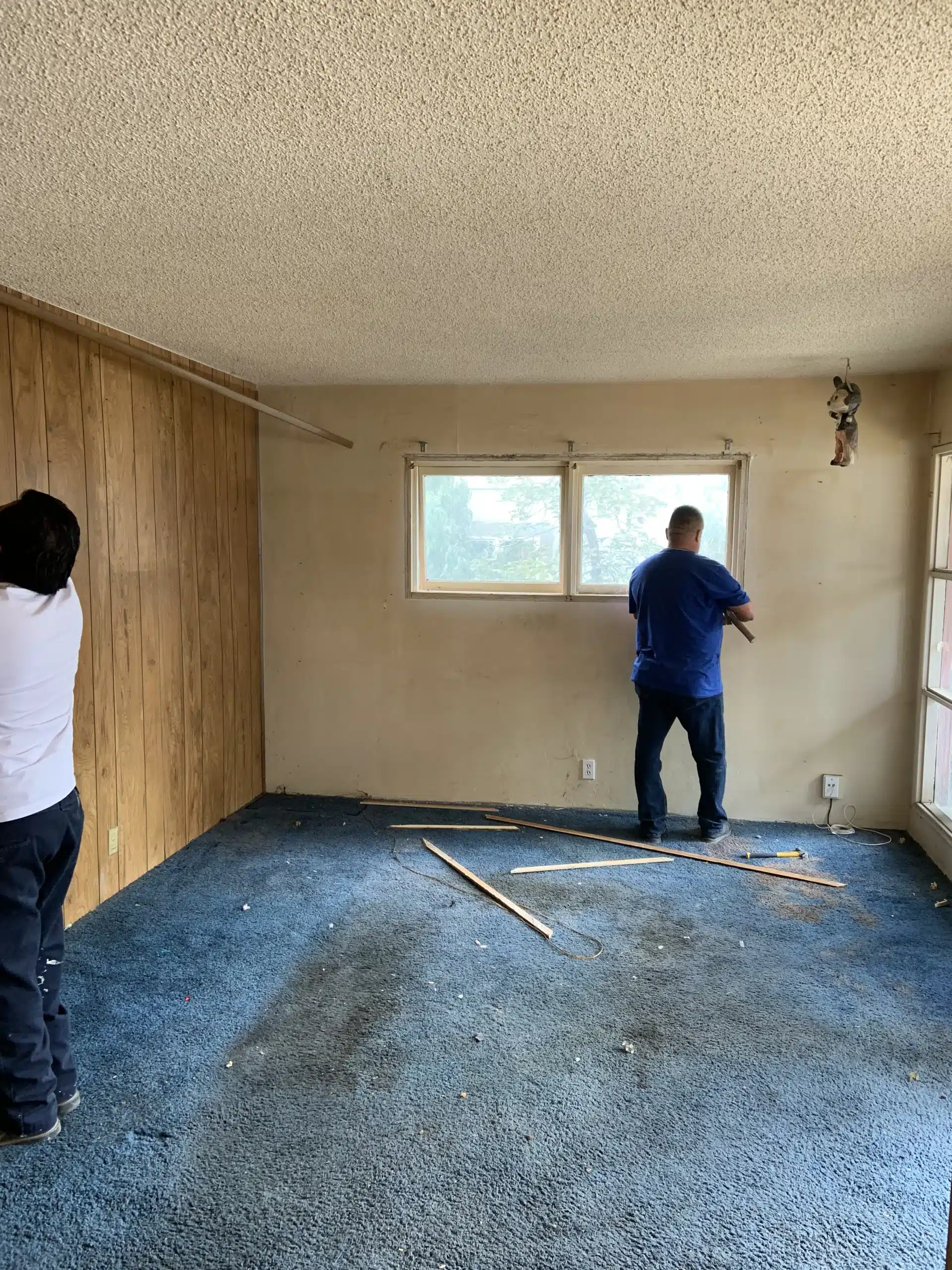 The Del Mar home before the remodel, with wood panelling, carpet and walls stripped back
