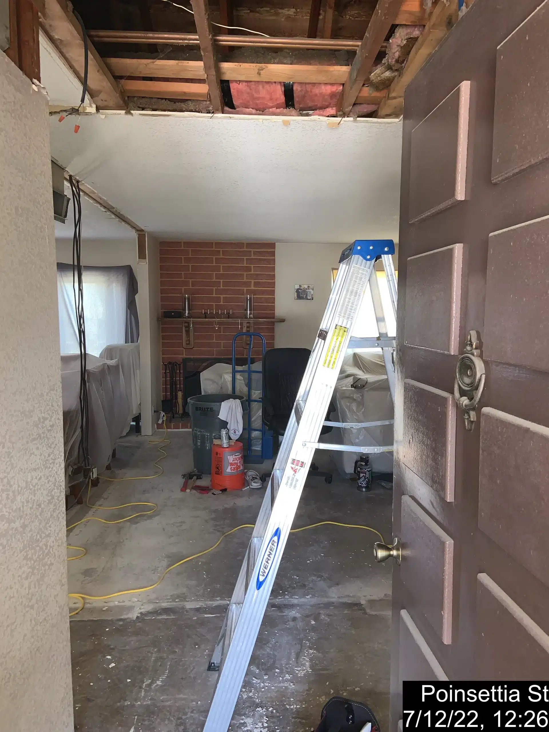 Ceiling opened to the joists during the Del Mar remodel, with the brick chimney and slab exposed