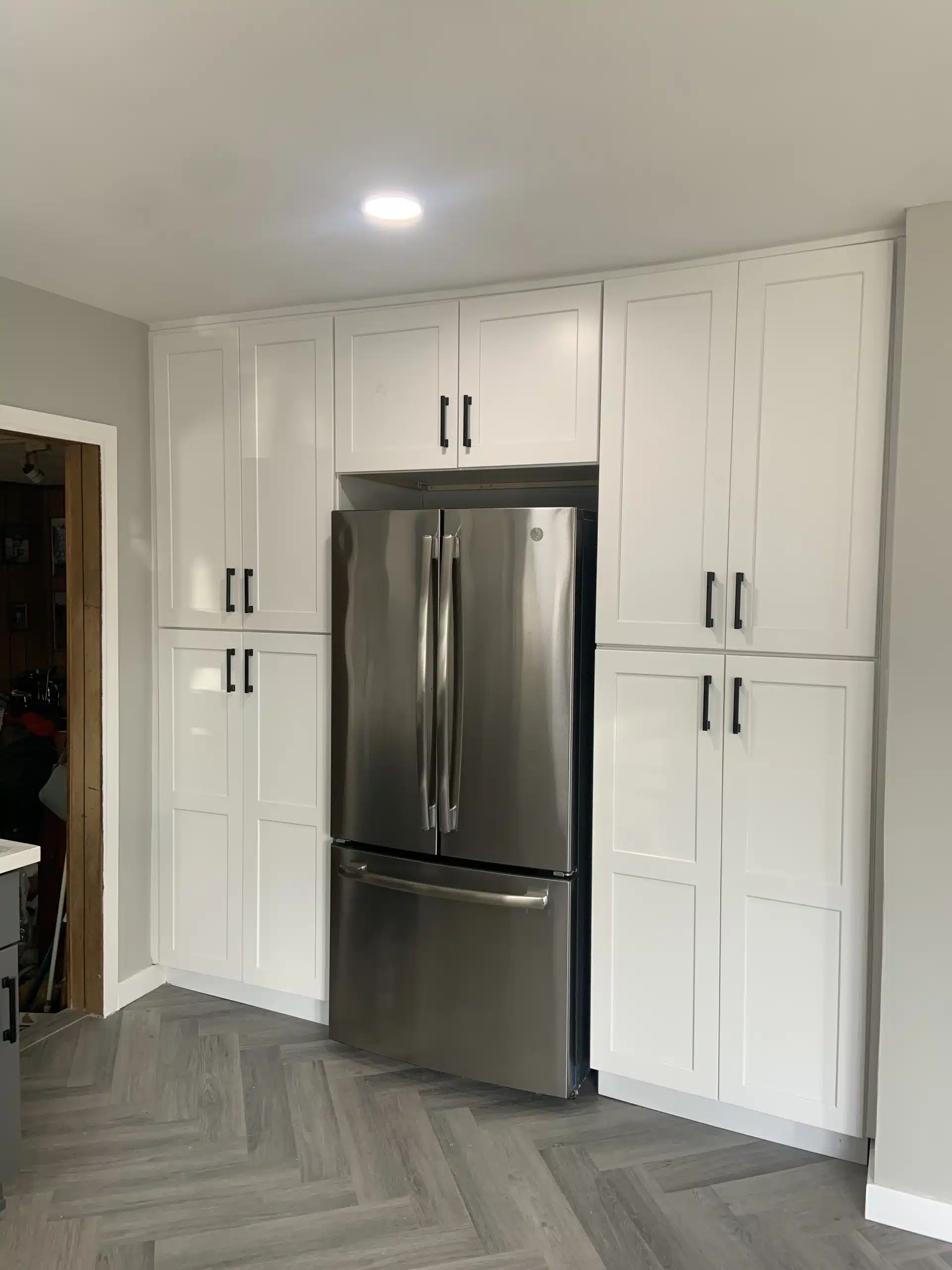 Full-height white cabinetry run in the completed Del Mar kitchen