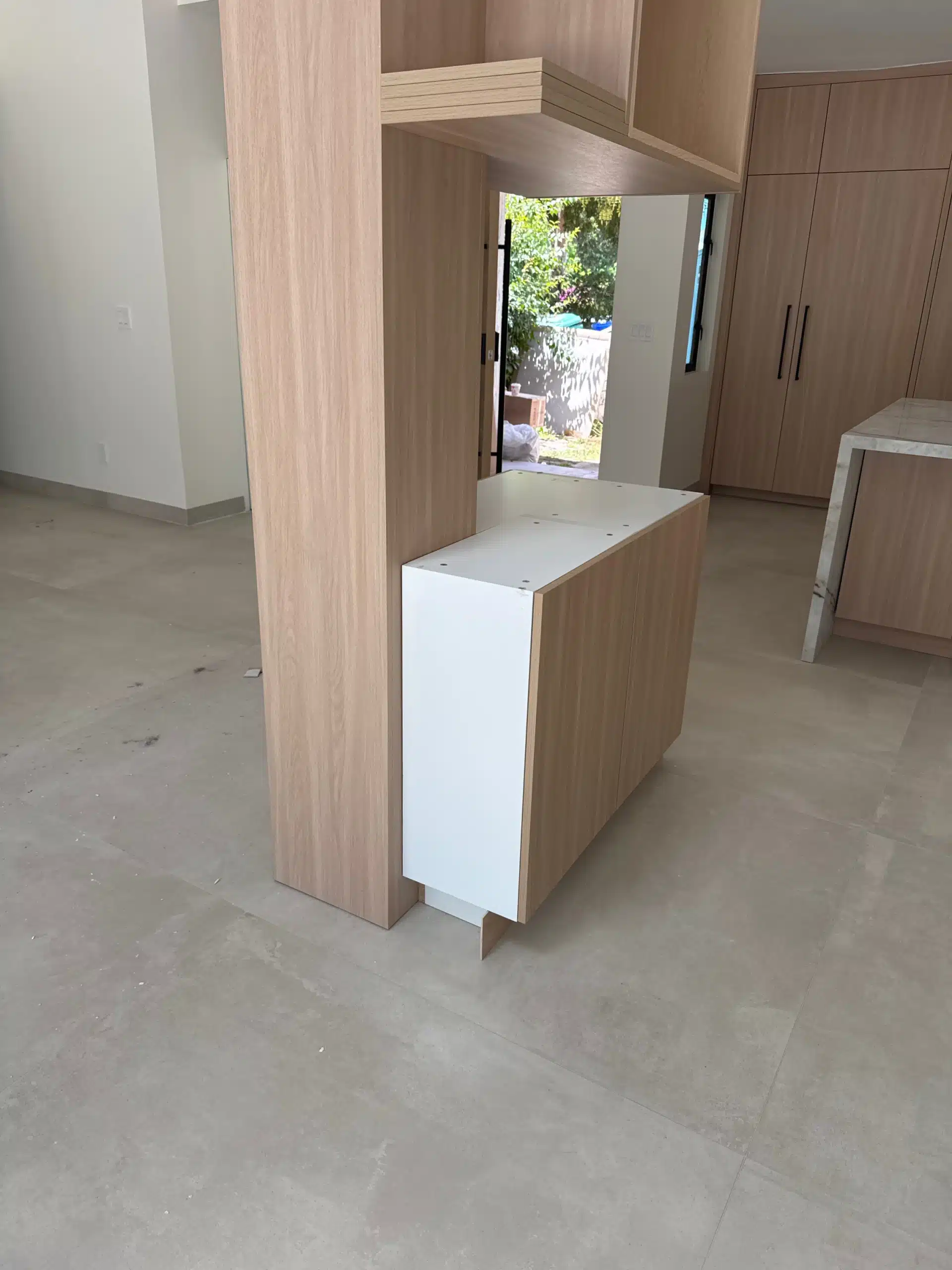 Detail of the oak cabinetry return and the marble island end panel