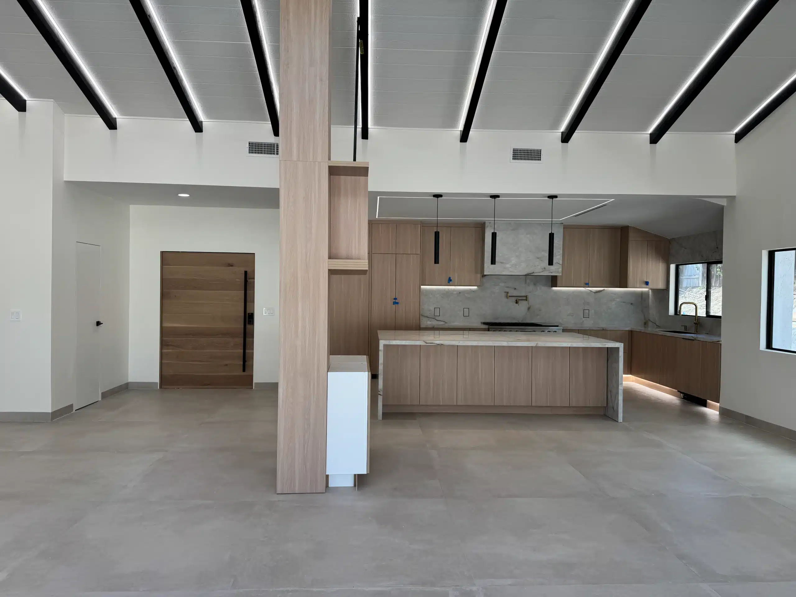 Kitchen island and structural column with the vaulted beamed ceiling above