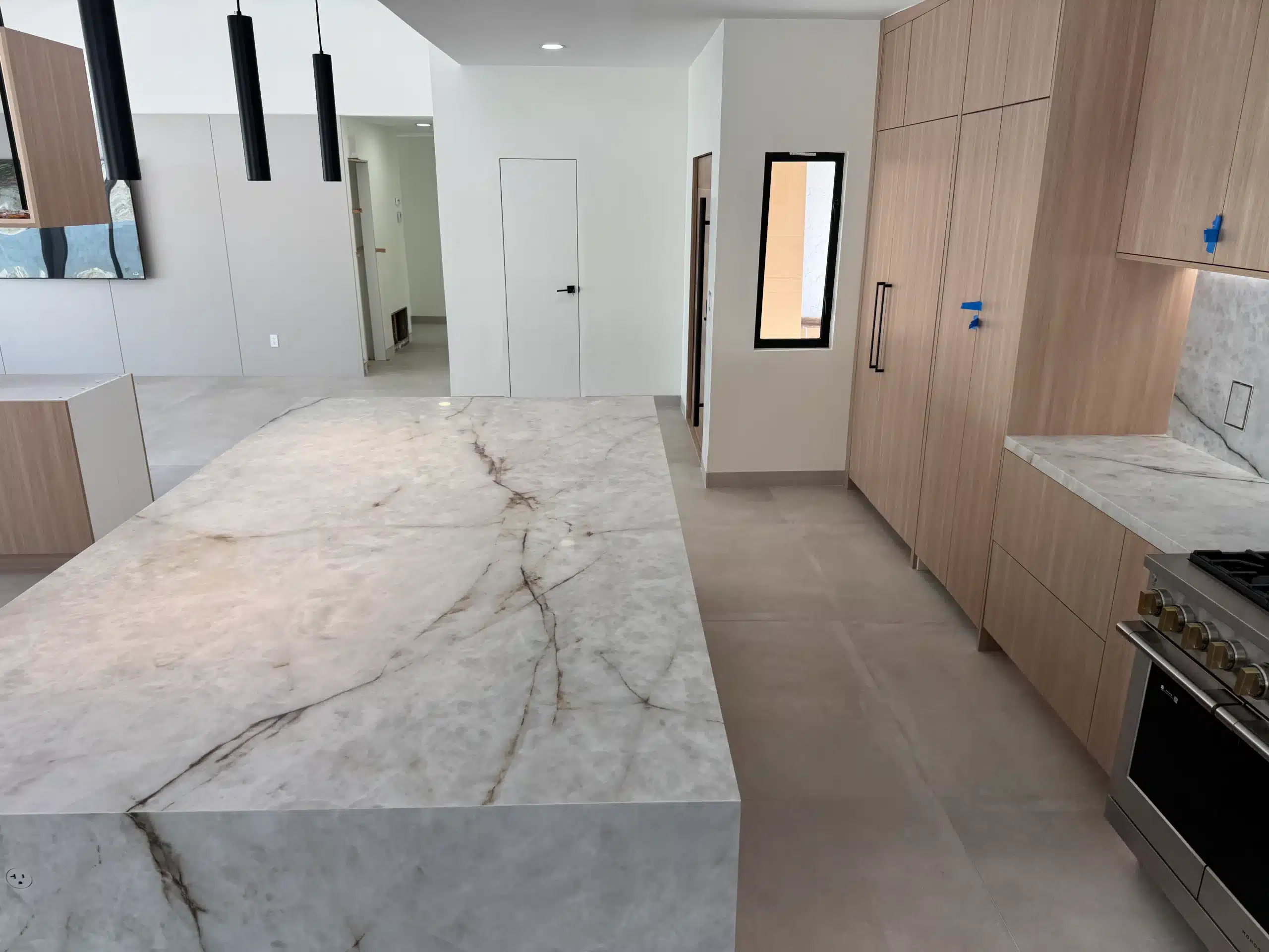 Close view of the veined marble island edge against light oak cabinetry in the Scripps Ranch kitchen