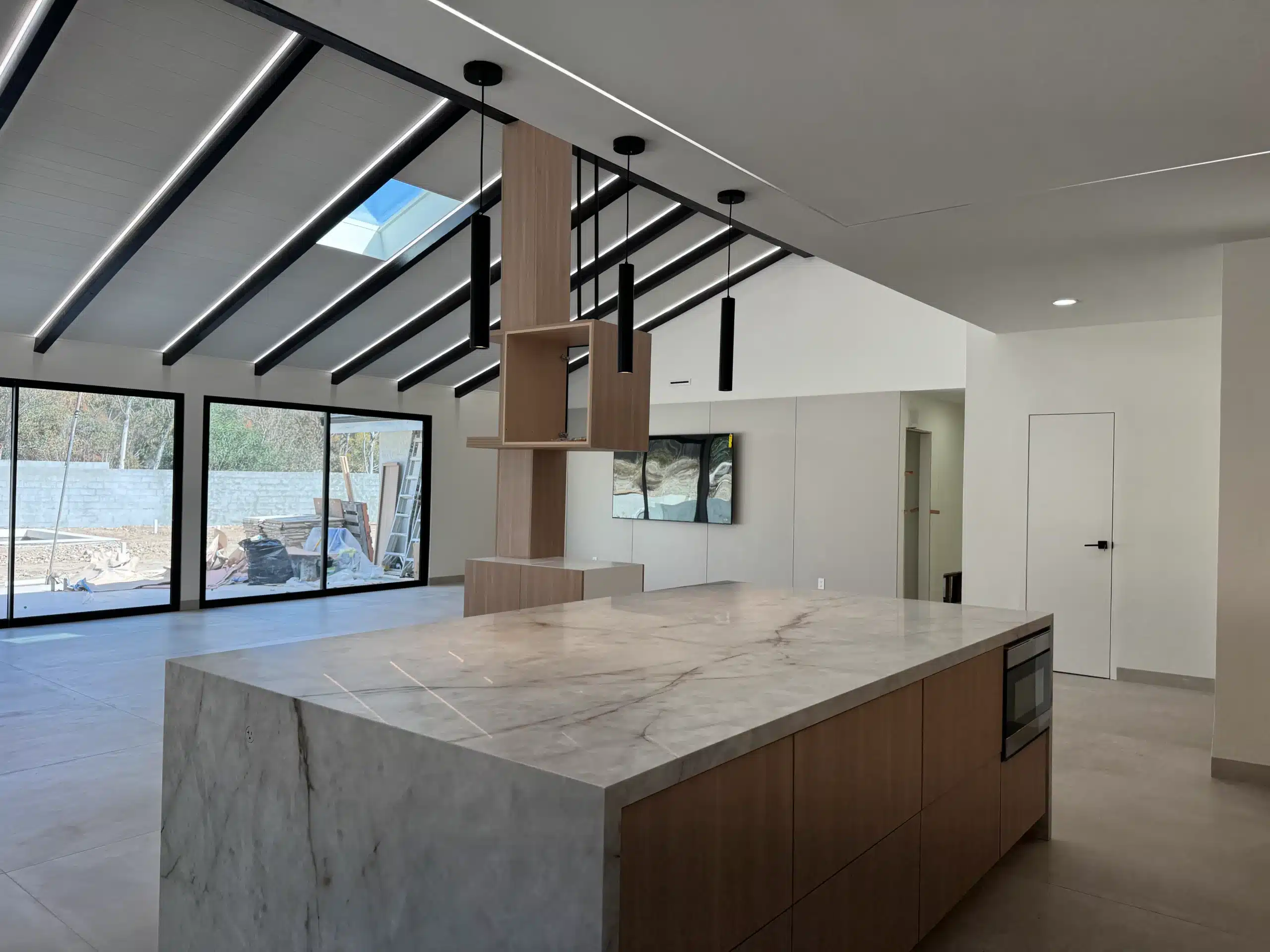 Living area of the Scripps Ranch whole-home remodel, showing the open span and vaulted ceiling with exposed black beams