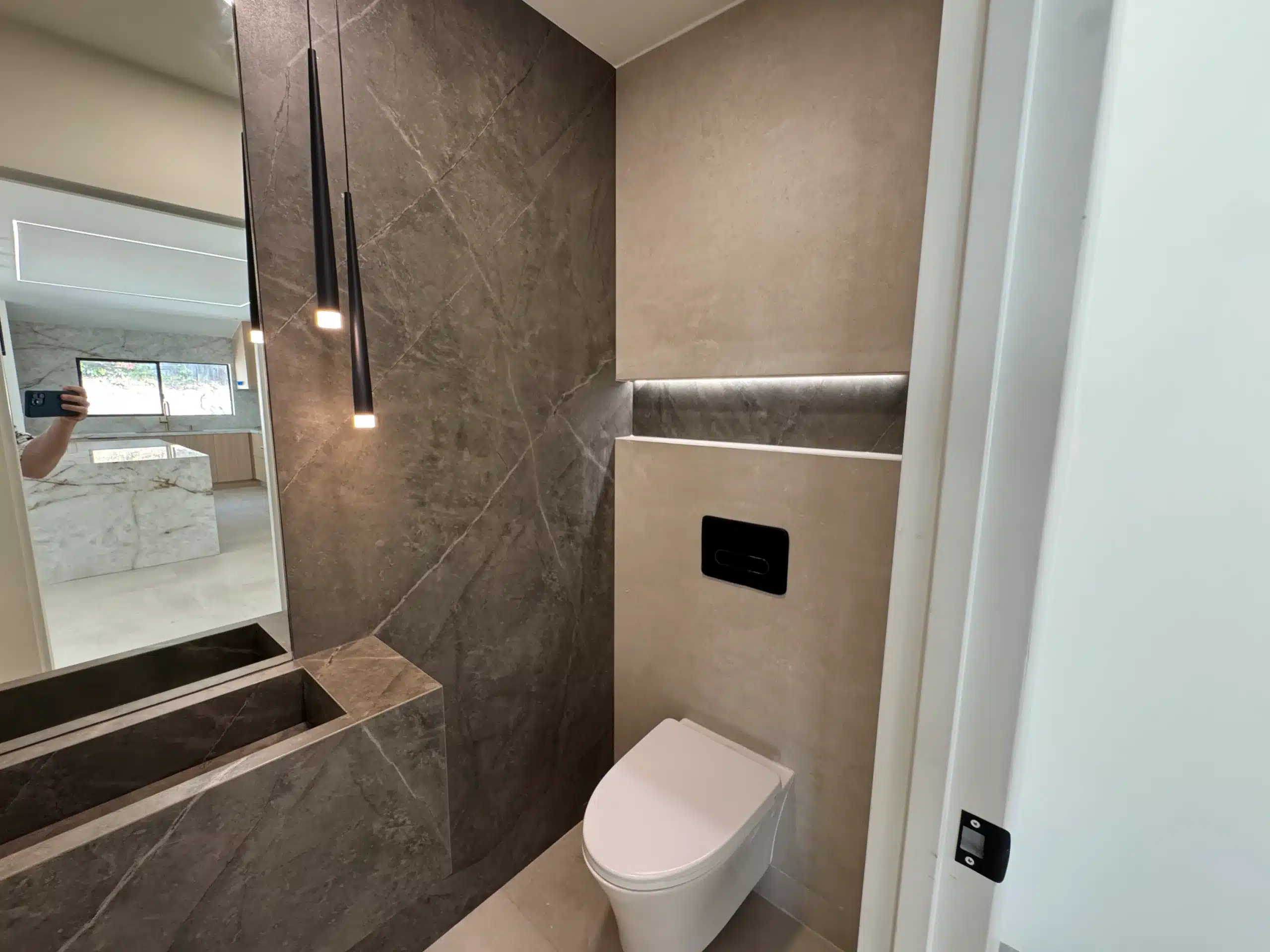 Second bathroom in large-format stone-look porcelain with a wall-hung toilet and step detail