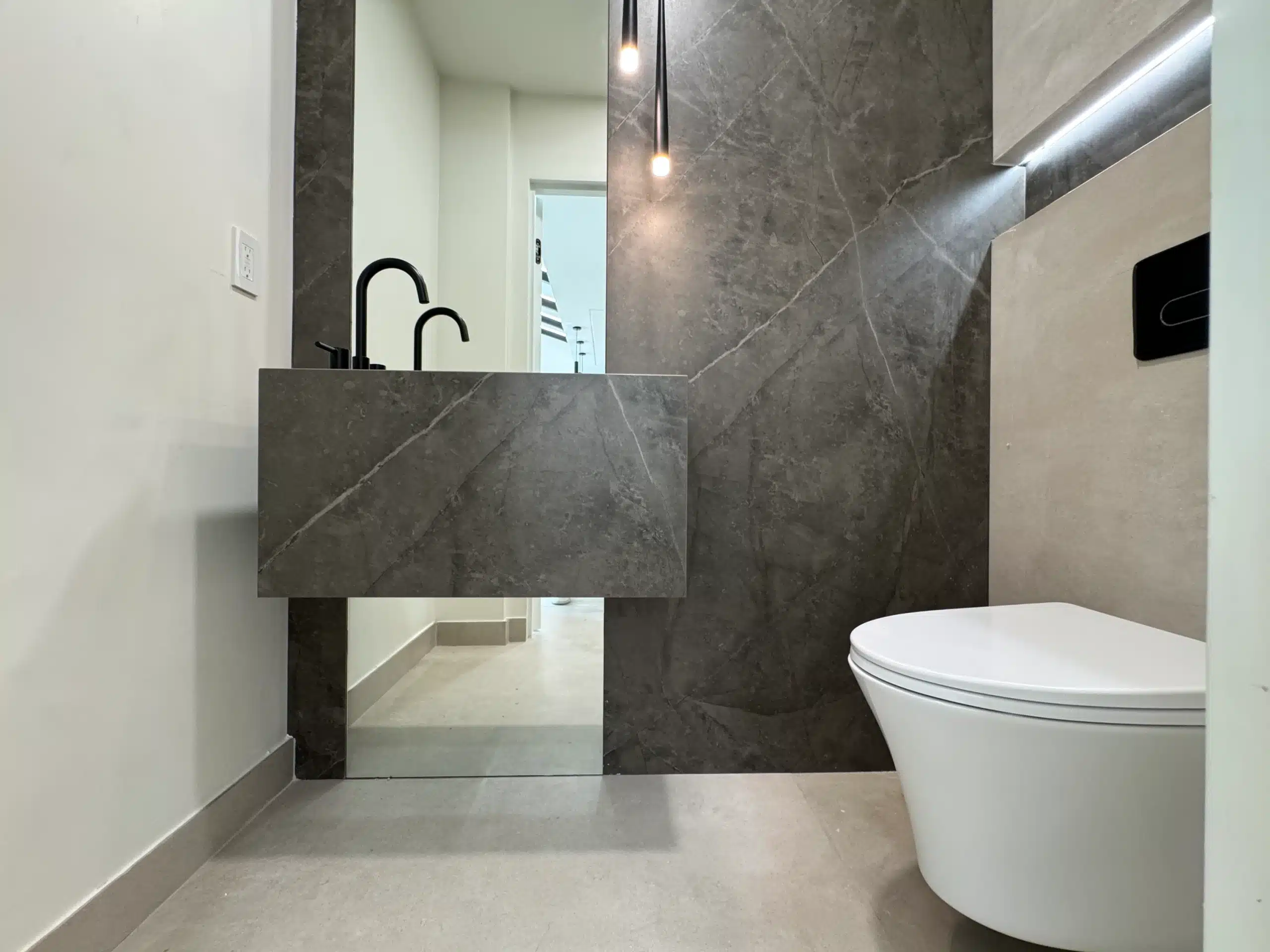 Completed Scripps Ranch remodel — stone-clad vanity and wall-hung fixtures in the second bathroom